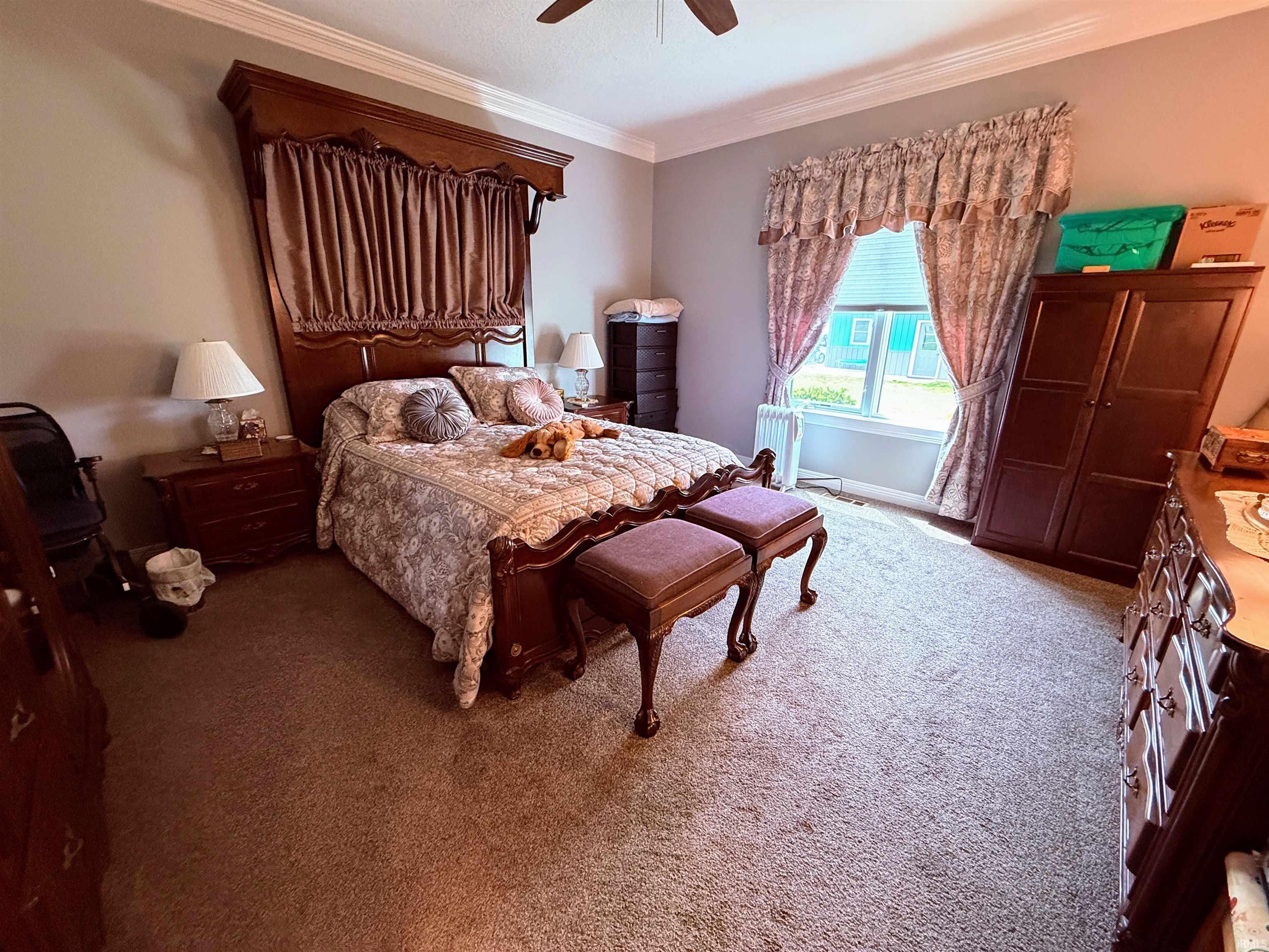 Carpeted room featuring a ceiling fan and a window with blinds