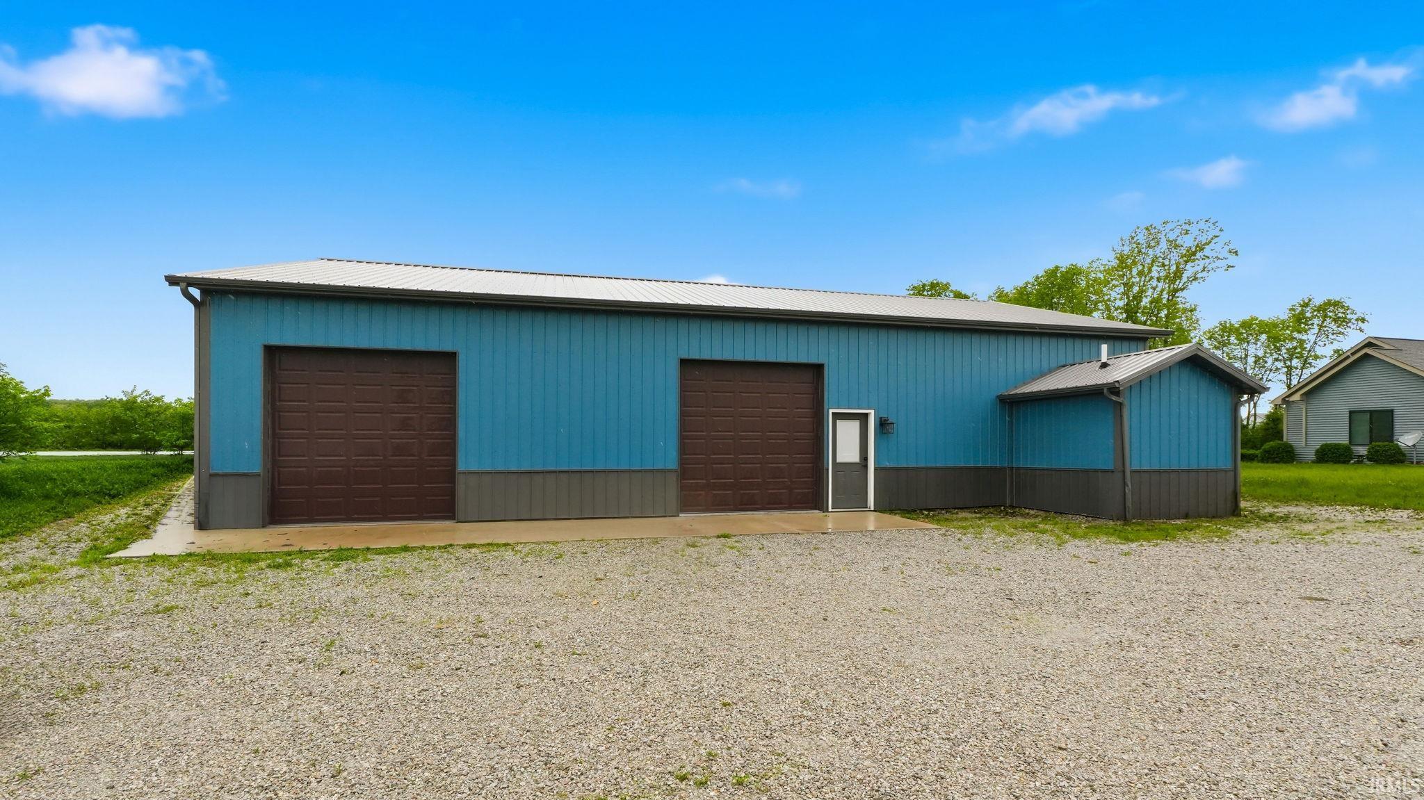 Large metal-sided utility building with a light blue and gray exterior