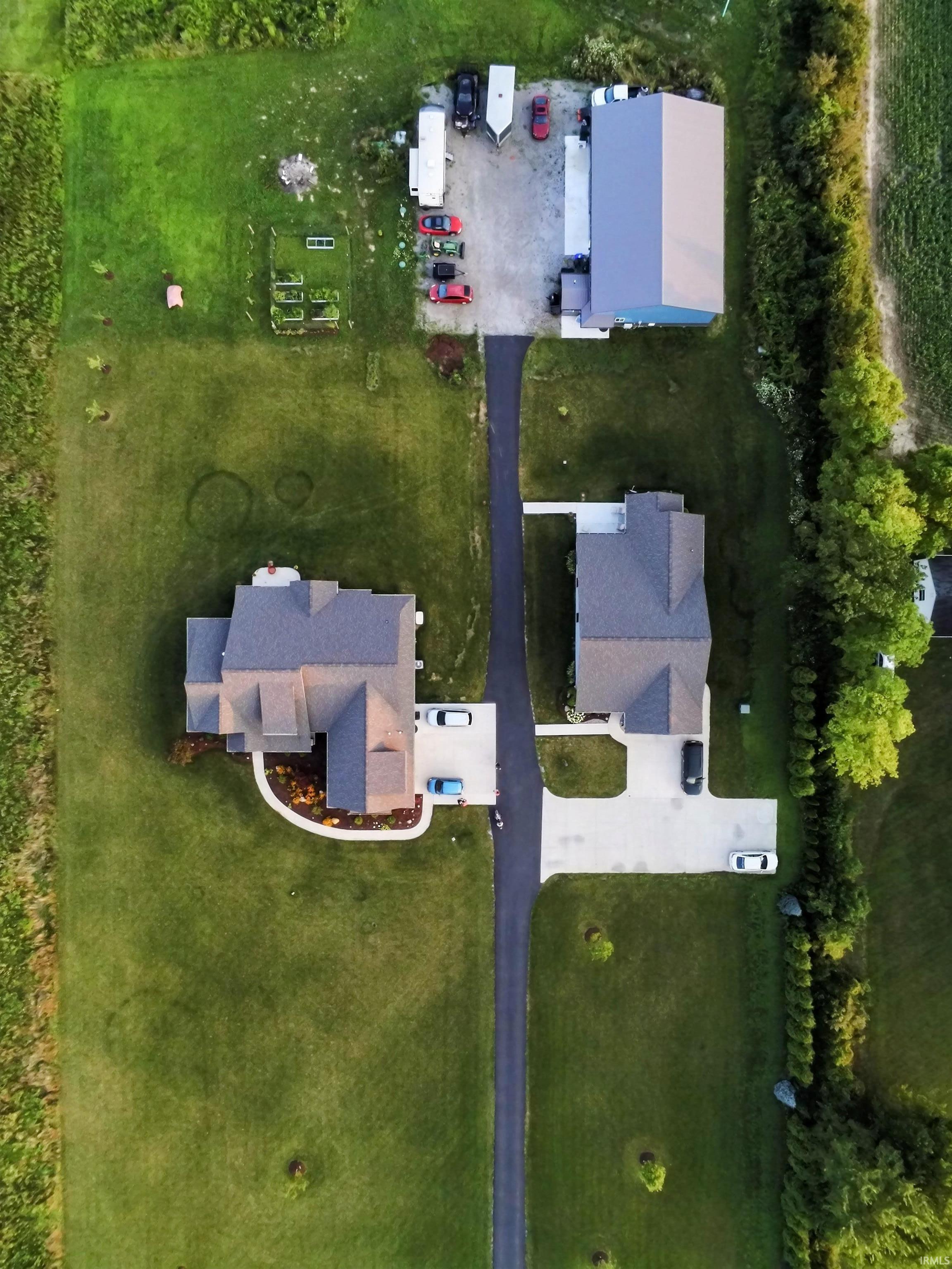 Expansive property featuring residential structures, a large barn, and a paved driveway