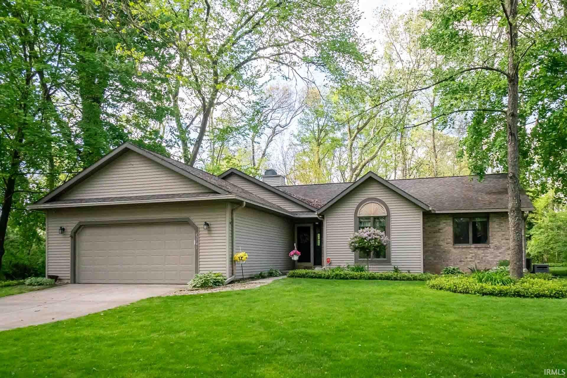 Ranch-style residence featuring a two-car garage, partial stone facade, and horizontal siding