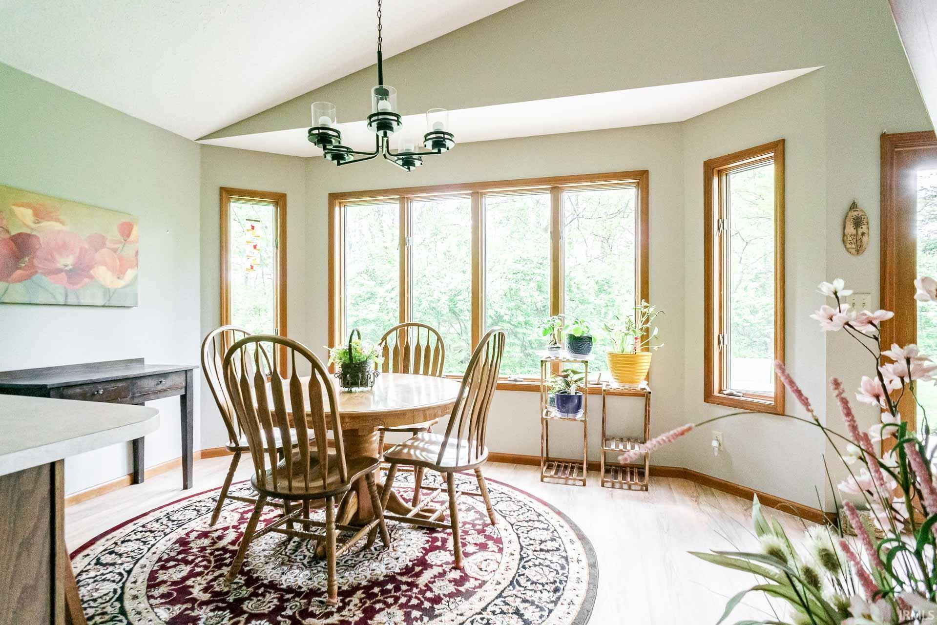 Dining area featuring a vaulted ceiling and a contemporary chandelier