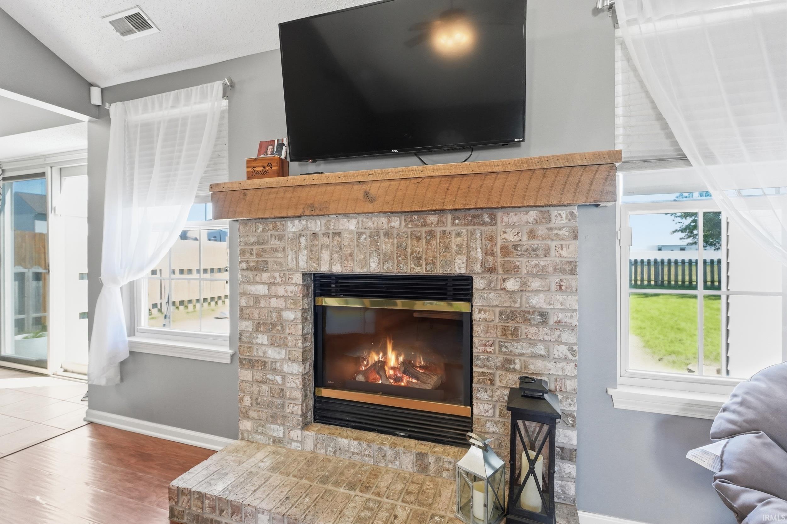 Brick-clad fireplace with a wood-finish mantel and integrated firebox