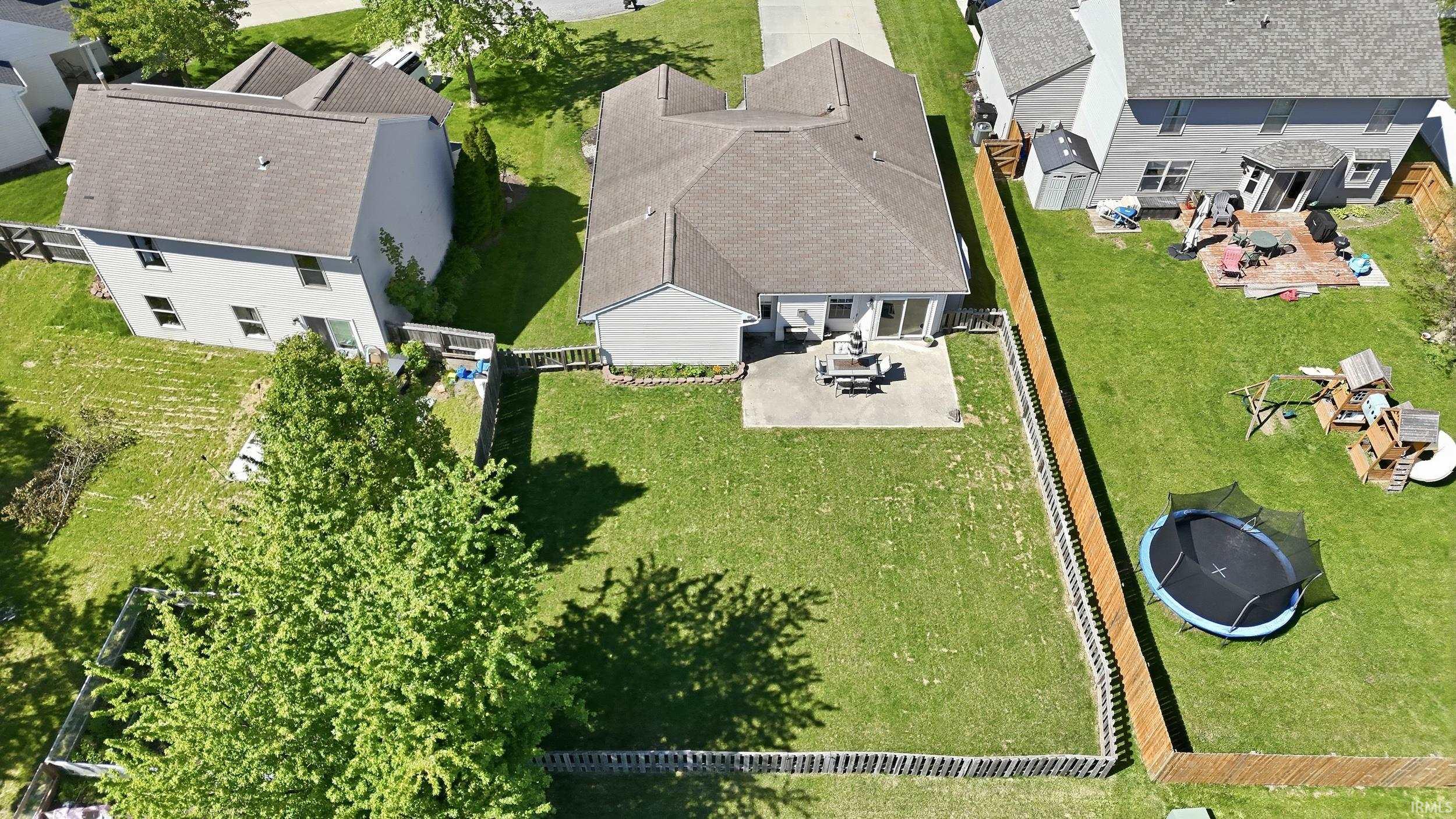 Spacious backyard featuring a manicured lawn, full perimeter fencing, and a concrete patio