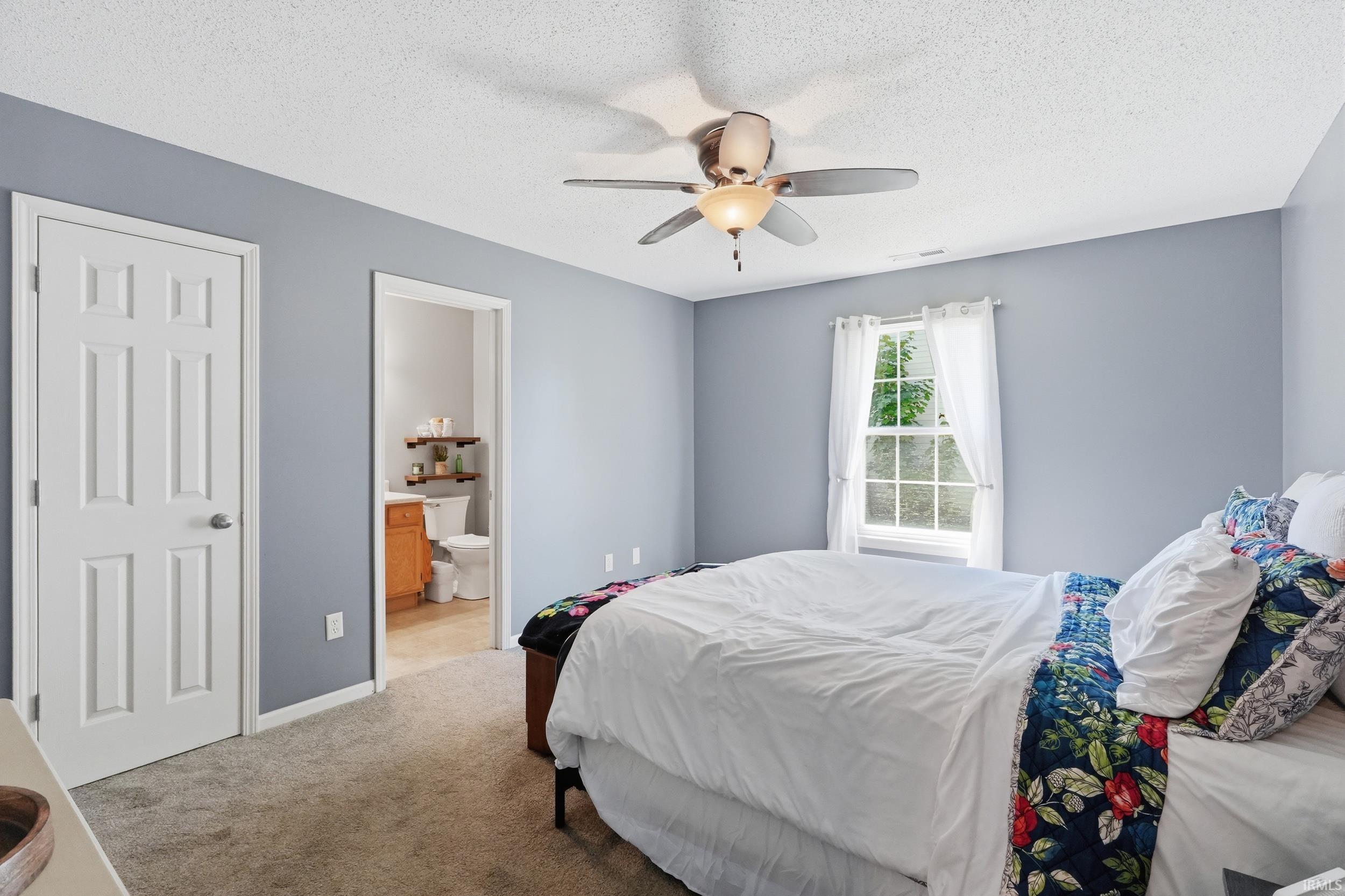 Bedroom featuring carpet flooring, a multi-pane window, and a ceiling fan with integrated lighting