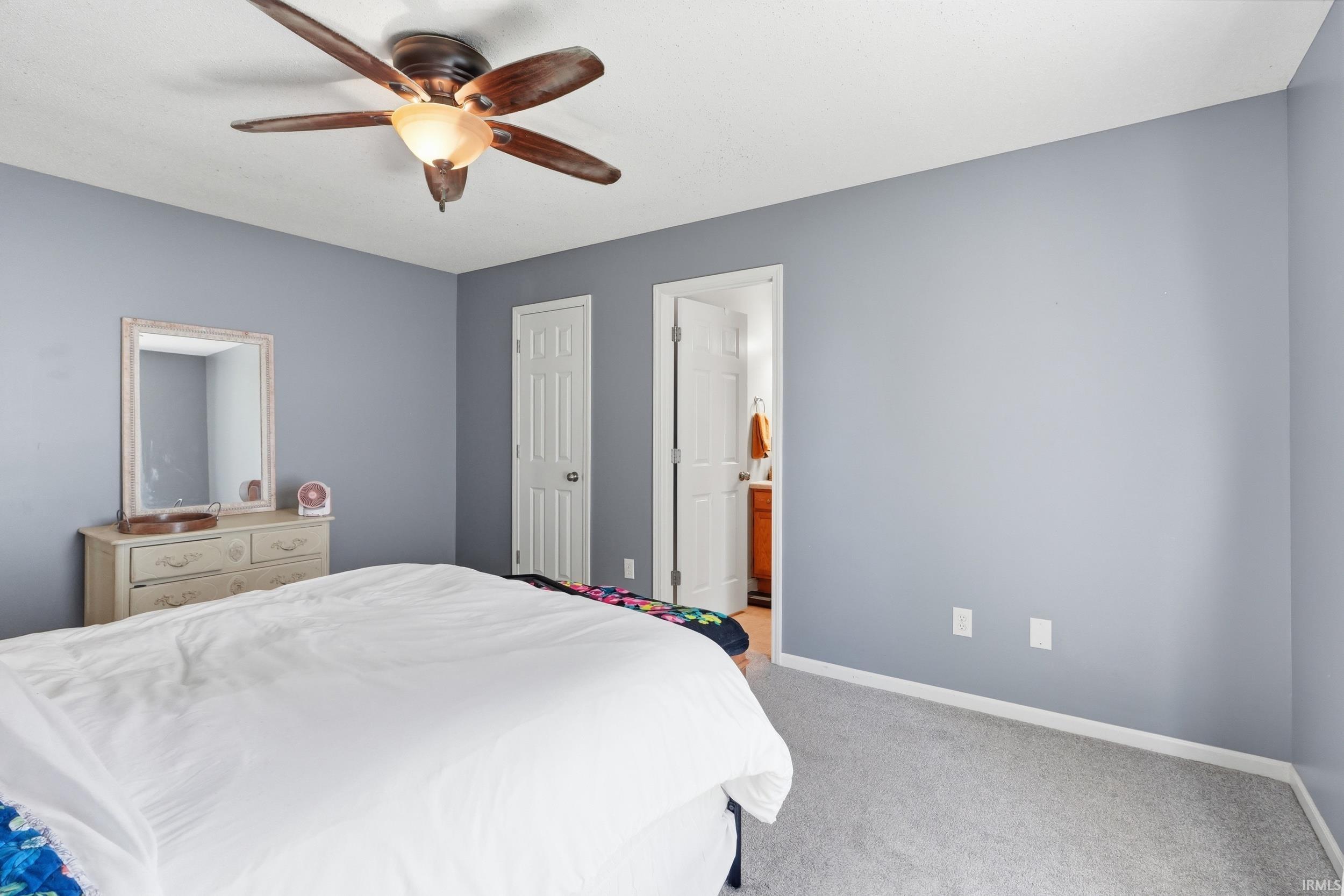 Bedroom with gray wall finishes and light-colored carpeting