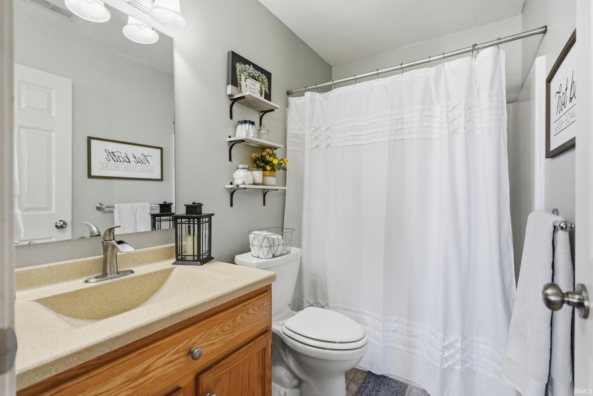 Bathroom featuring a wood-finish vanity with a built-in sink and single-handle faucet