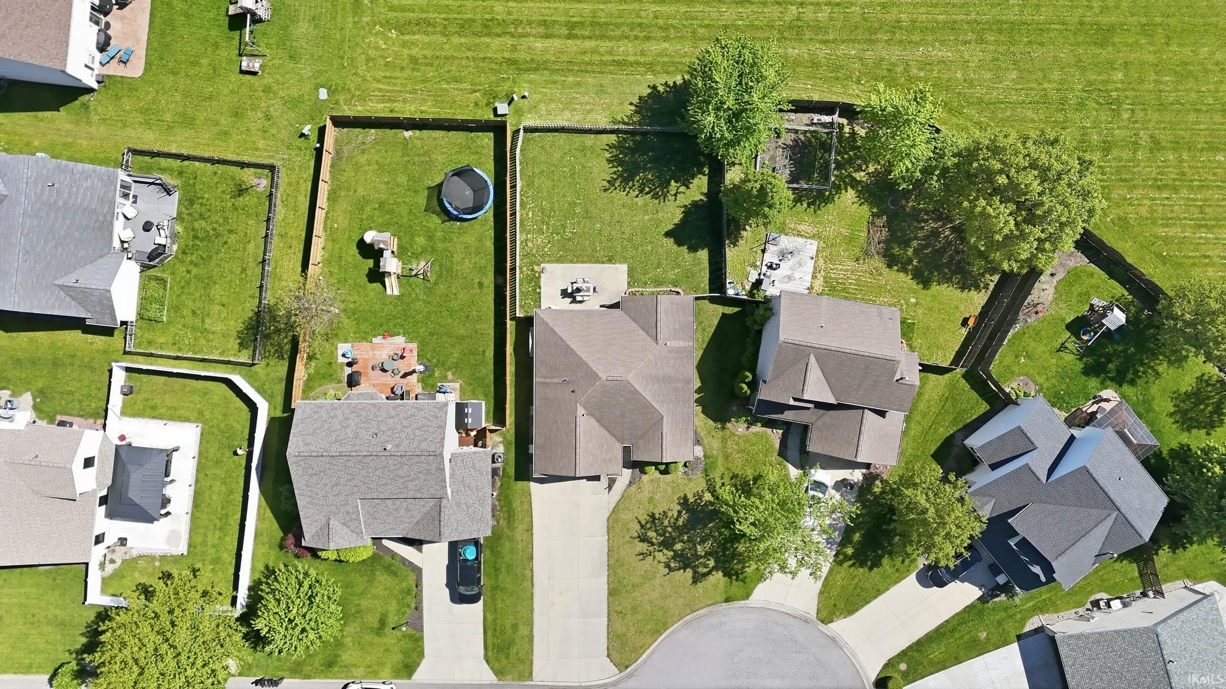 Aerial view of a residential property with a shingled roof and an attached garage