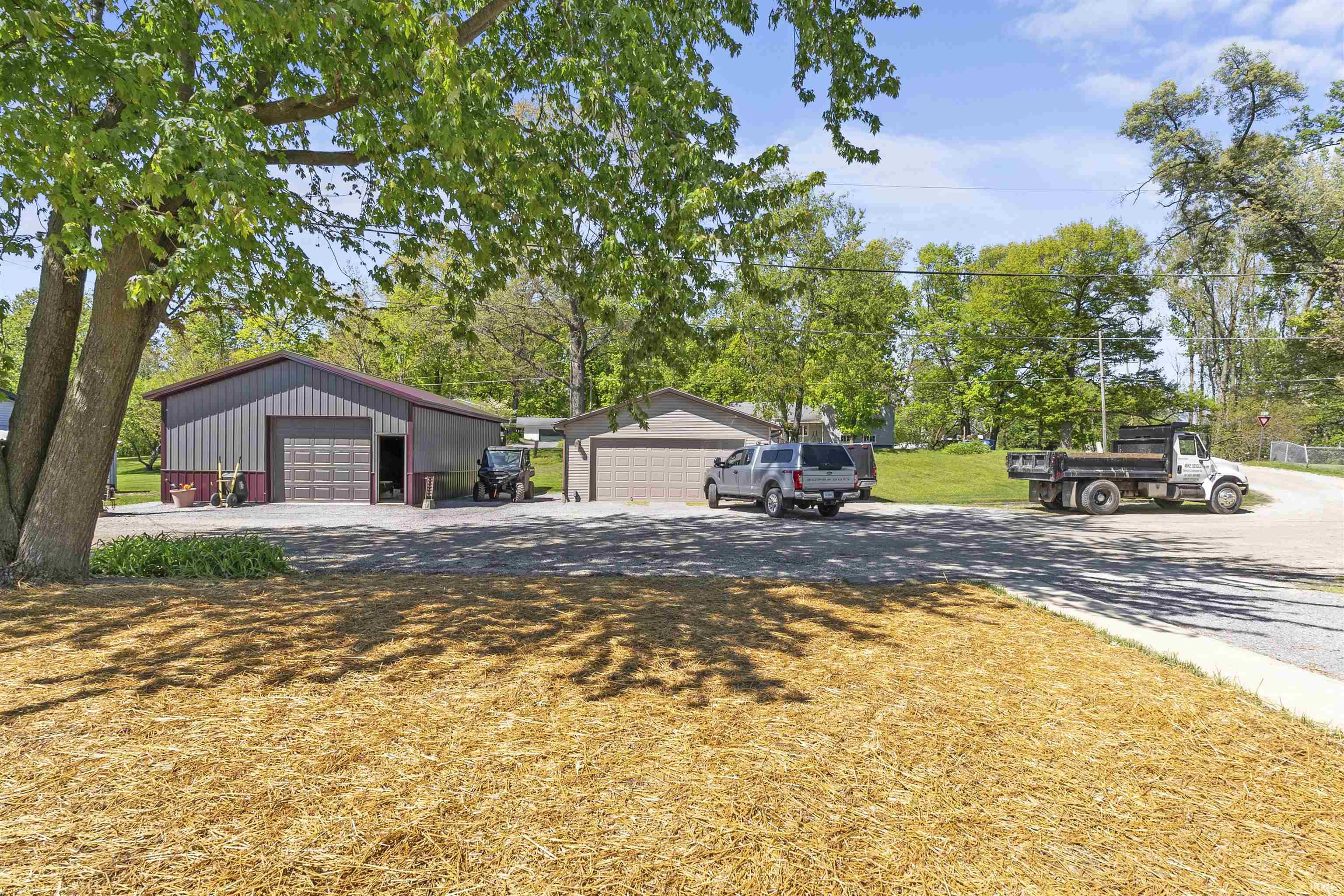 Gray metal outbuilding featuring a brown garage door and brown trim