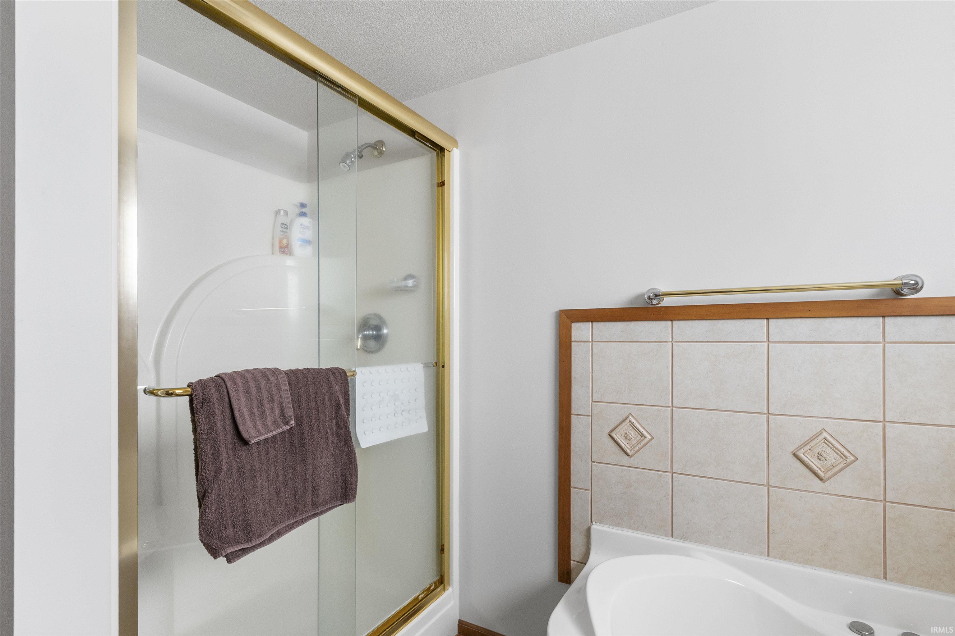 Shower with gold-toned frame and clear glass door
