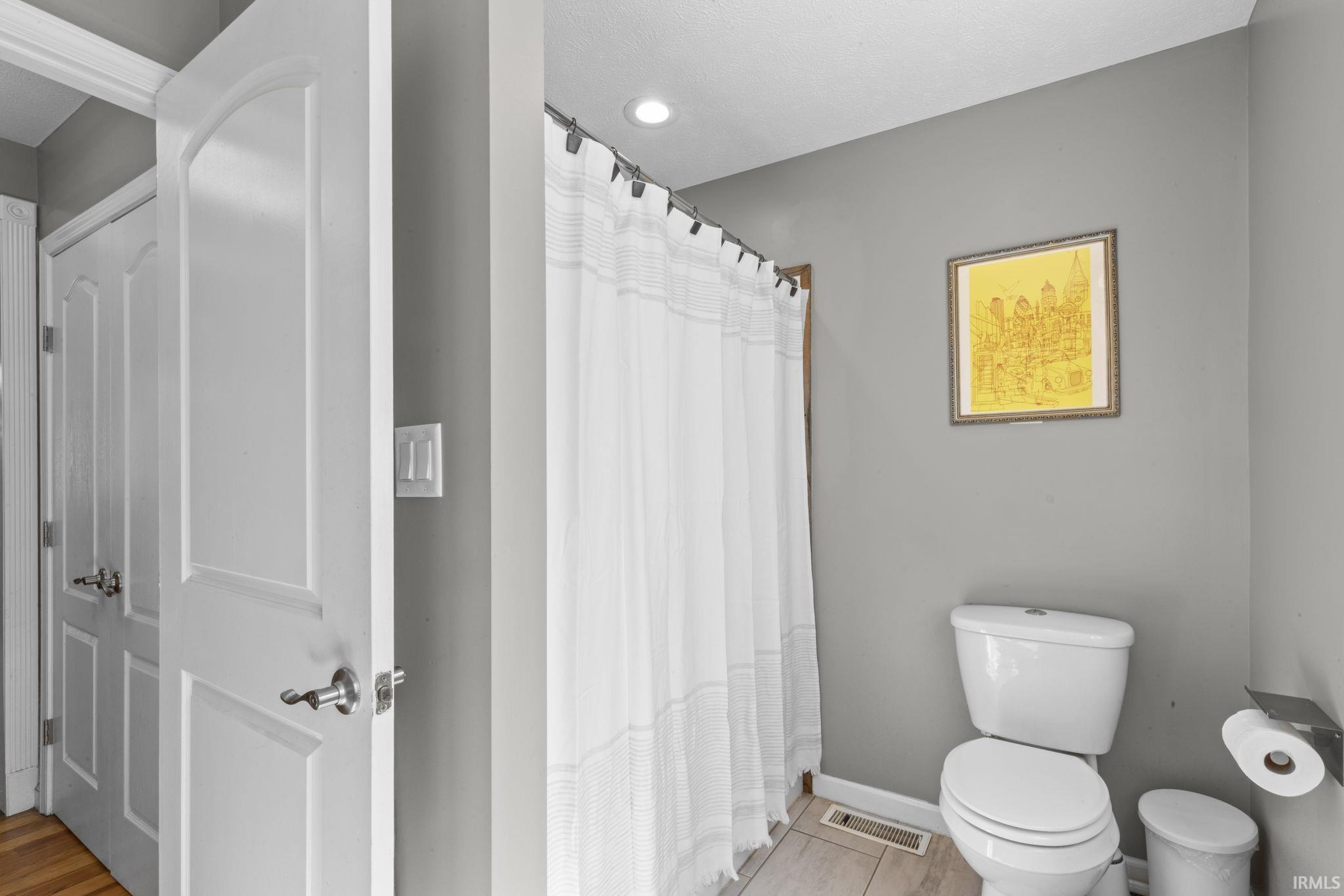 Full bathroom featuring gray walls, recessed lighting, and light-toned tile flooring