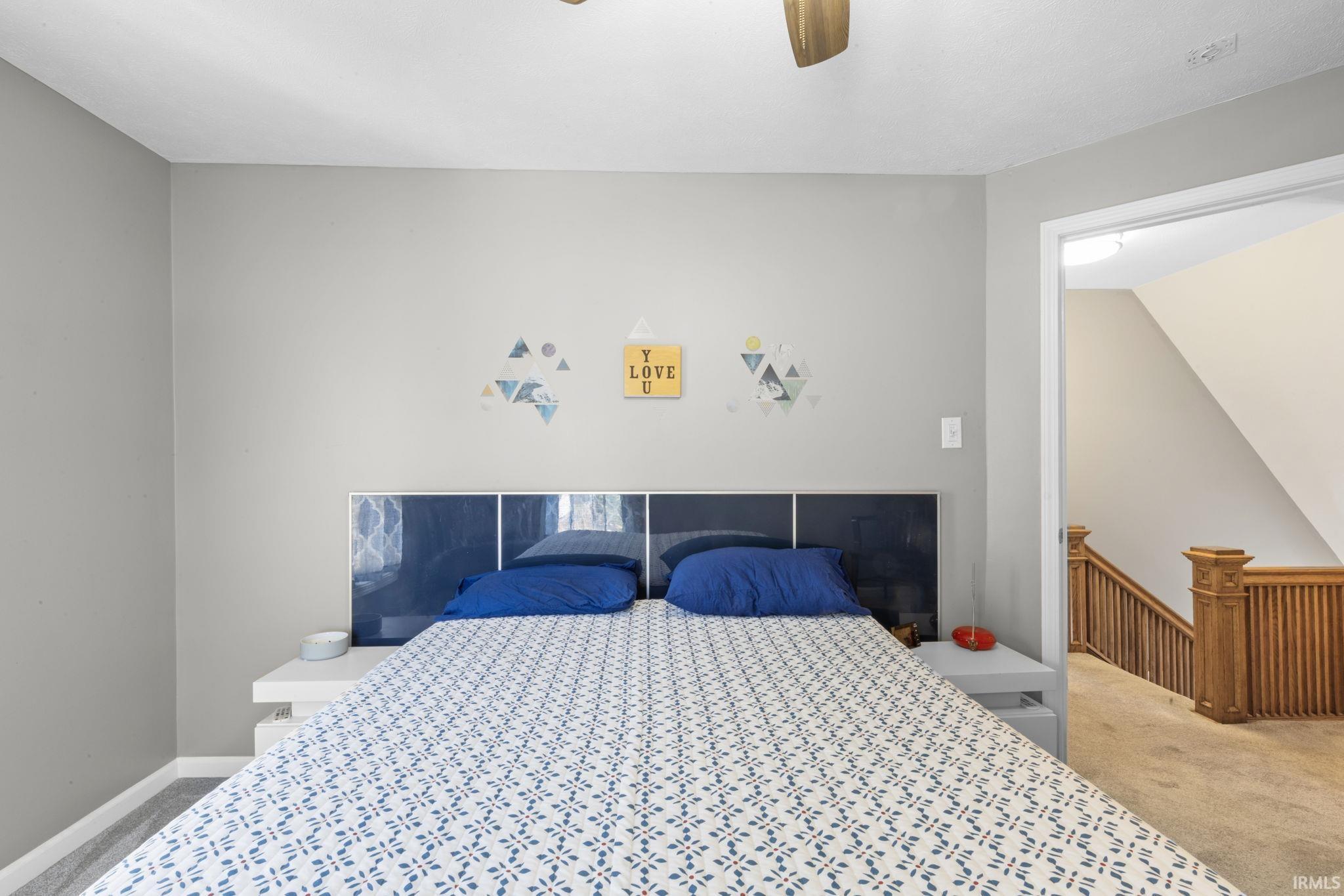 Bedroom featuring light grey walls and a ceiling fan