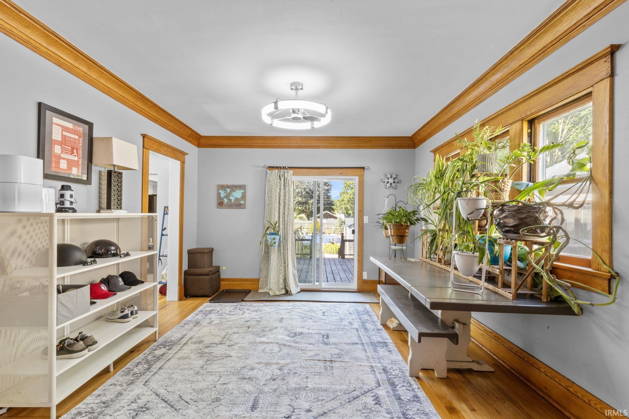 Spacious room featuring wood-finish flooring, light grey walls, and extensive wood trim