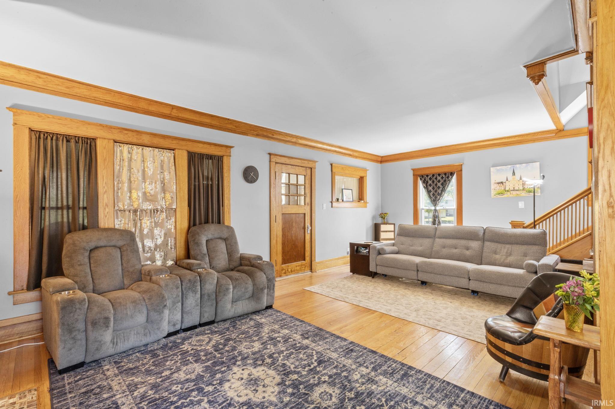 Hardwood flooring complements light-toned walls and natural wood trim throughout this living space