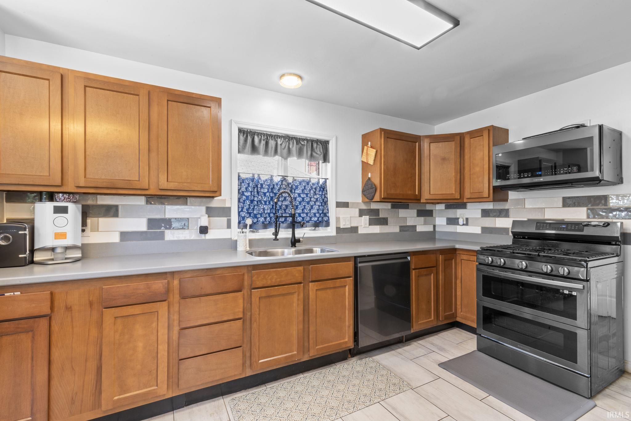 Kitchen featuring wood cabinetry, stone-look countertops, and a tiled backsplash