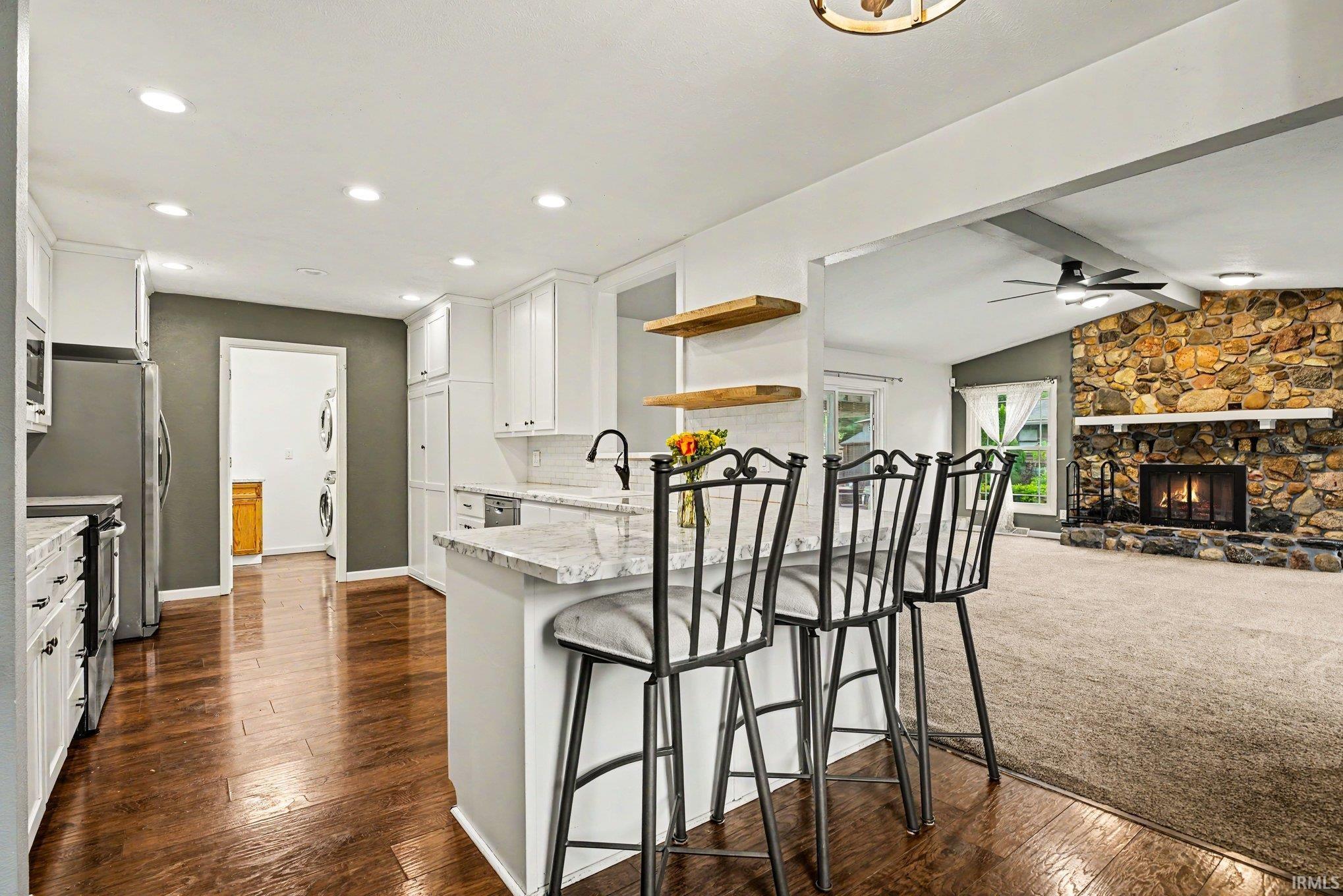 Kitchen island with a light-toned countertop, white cabinetry, and wood-finish flooring