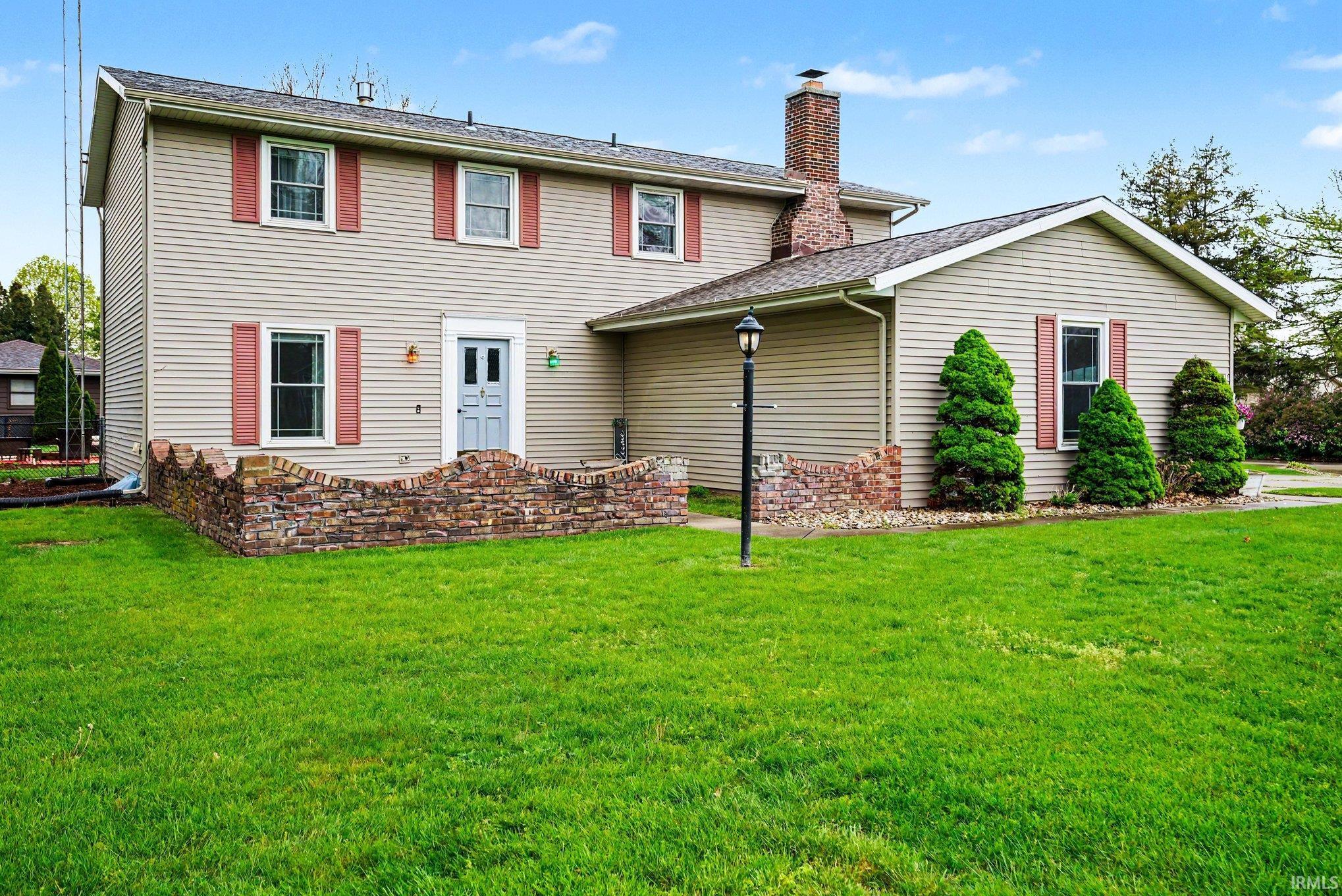 Two-story property with light beige siding and red decorative shutters