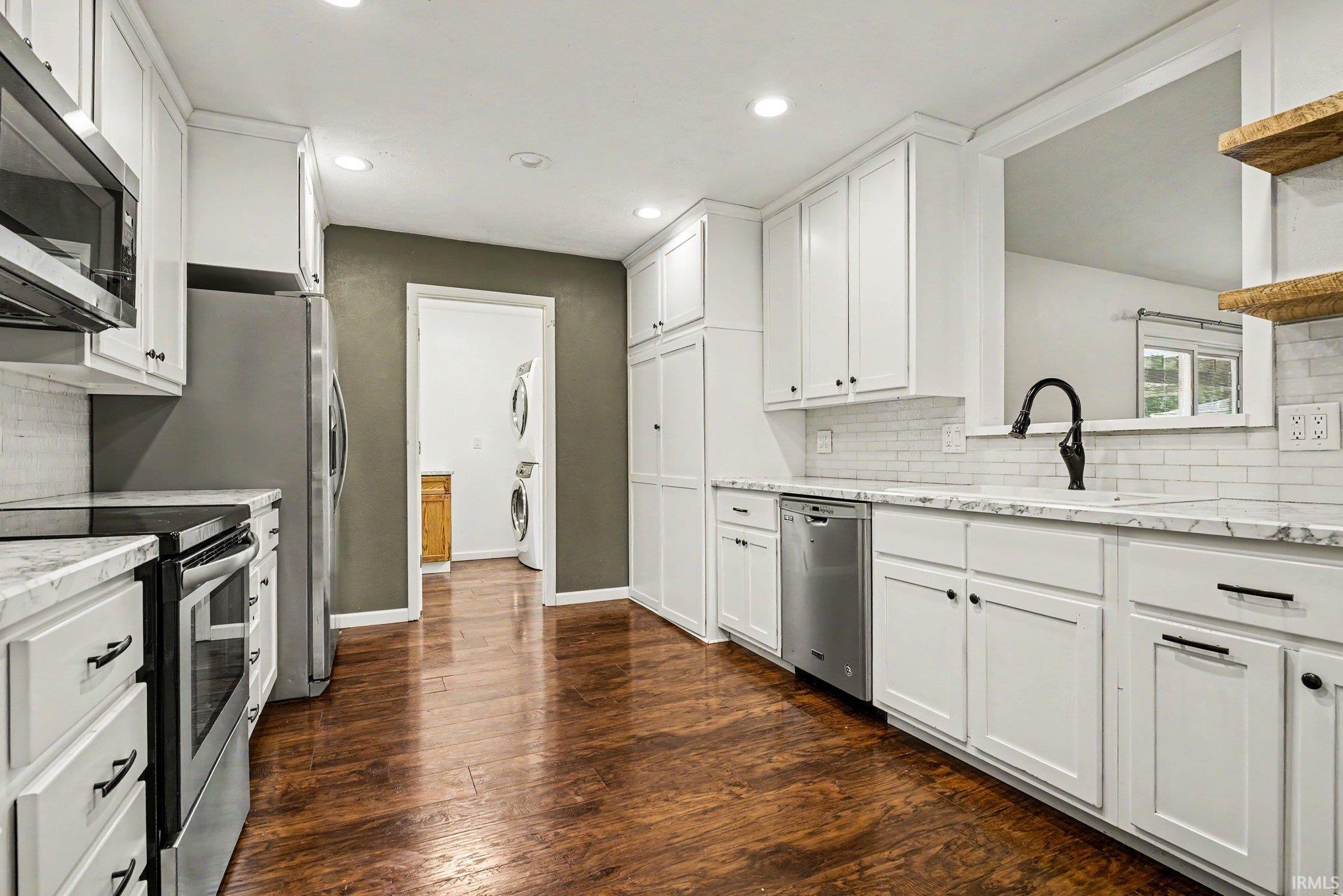 Kitchen featuring white cabinetry, wood-finish flooring, recessed lighting, and stainless steel appliances
