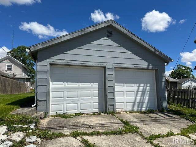 Two-car detached garage with panel-style doors and shingle siding