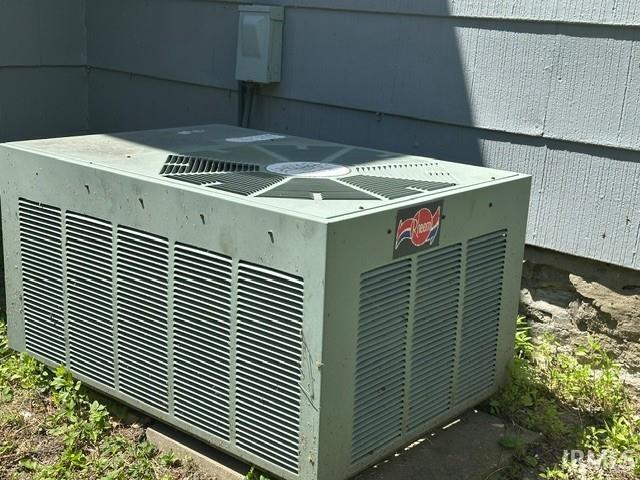 Outdoor air conditioning unit with side grilles and top-mounted fan