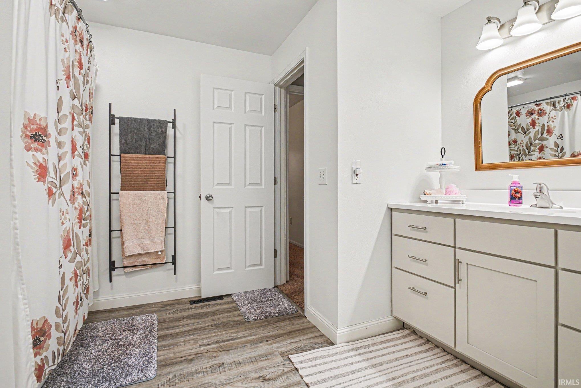 Bathroom featuring a single vanity with light-colored cabinetry and a white countertop