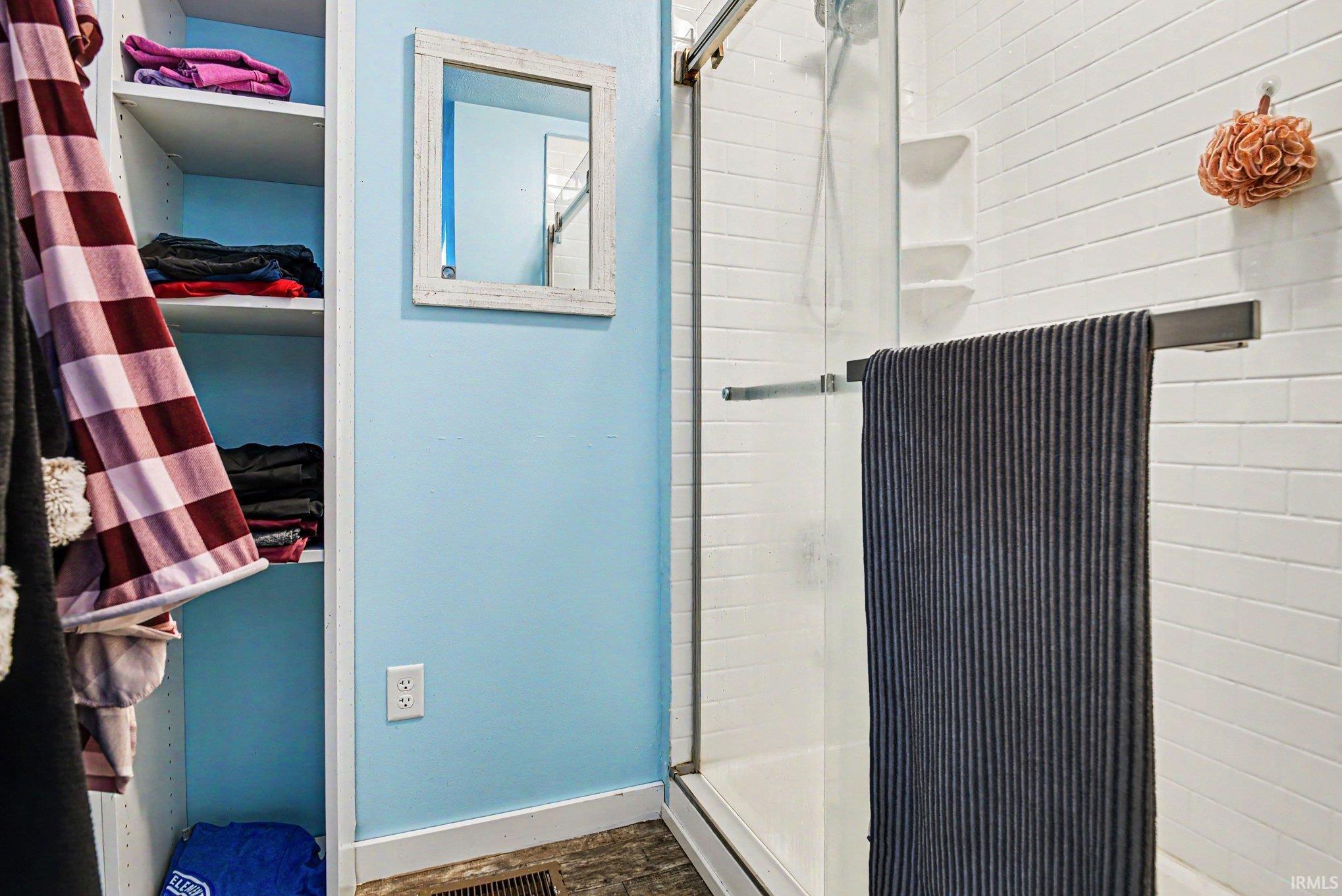 Shower enclosure featuring clear glass sliding doors and white subway tile surround