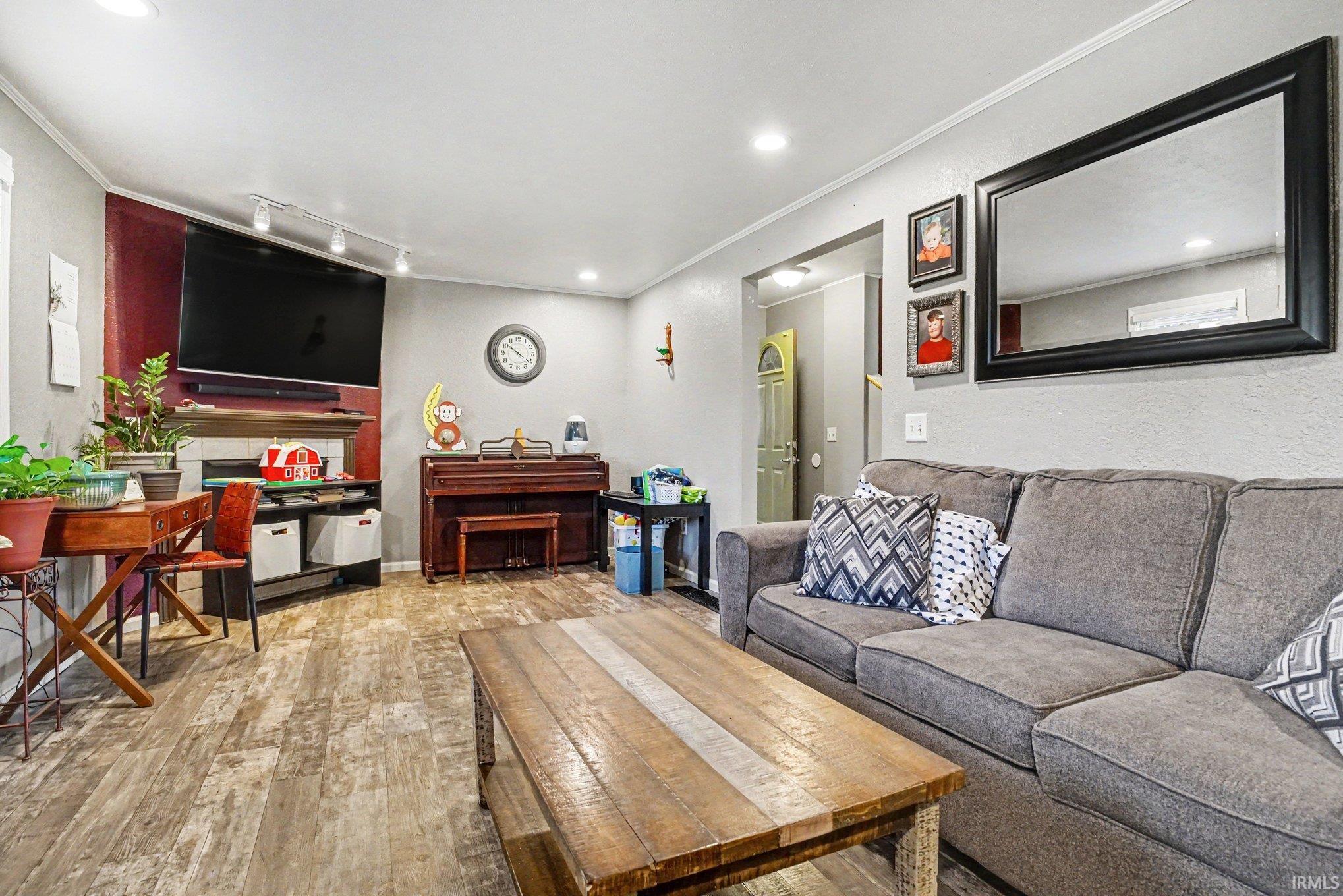 Living area featuring wood-finish flooring, recessed lighting, and a neutral wall palette
