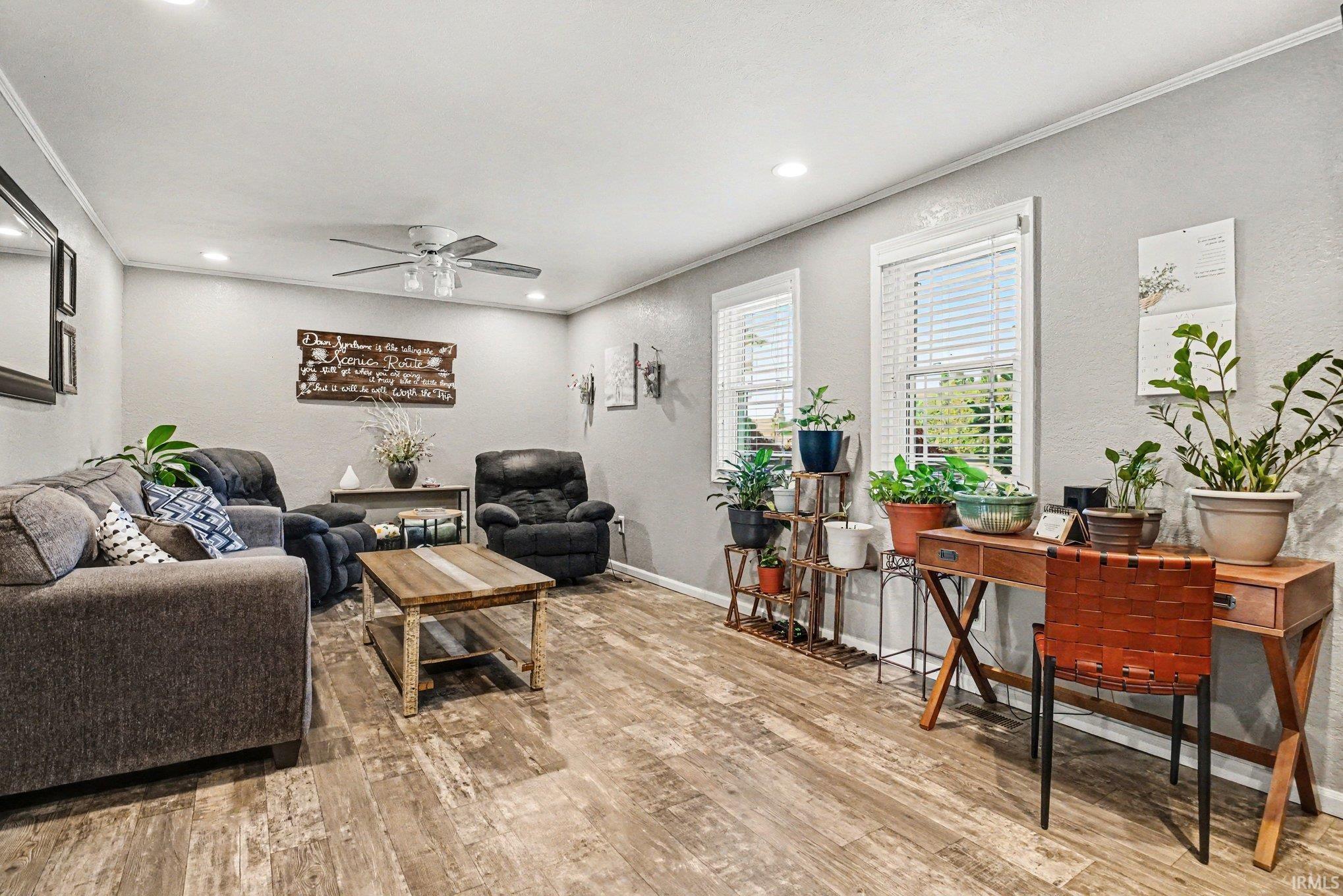 Spacious living area featuring wood-finish flooring, recessed lighting, and a ceiling fan