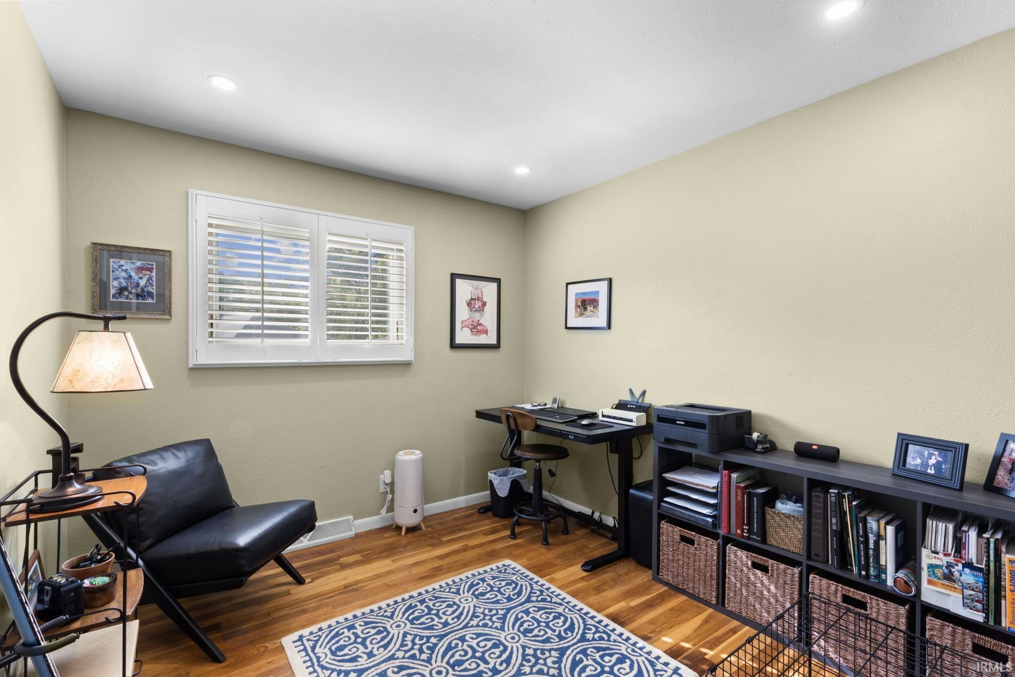 Interior space featuring wood-finish flooring, recessed lighting, and a window with white louvered blinds