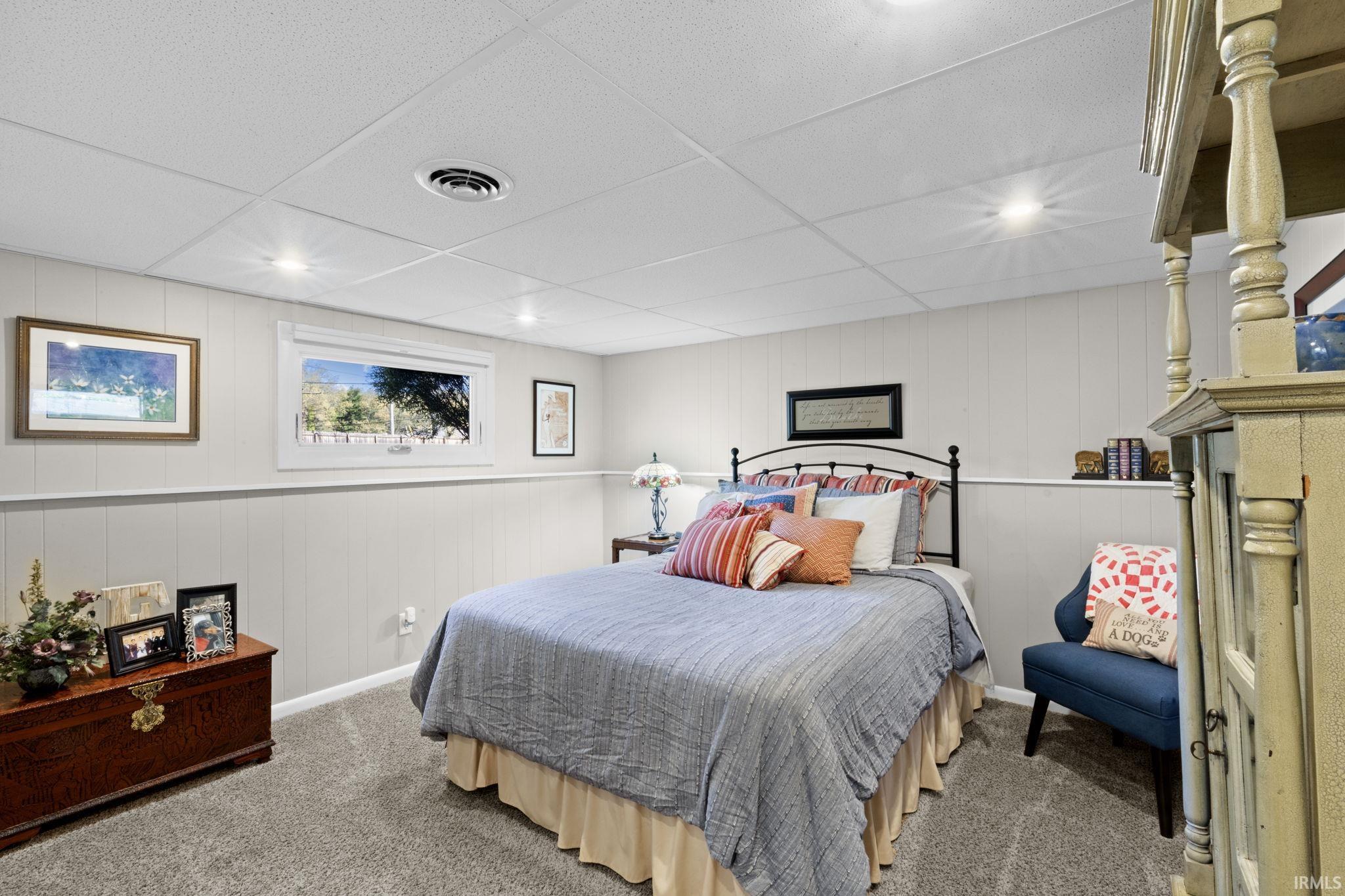 Carpeted room featuring a white paneled wall with chair rail molding