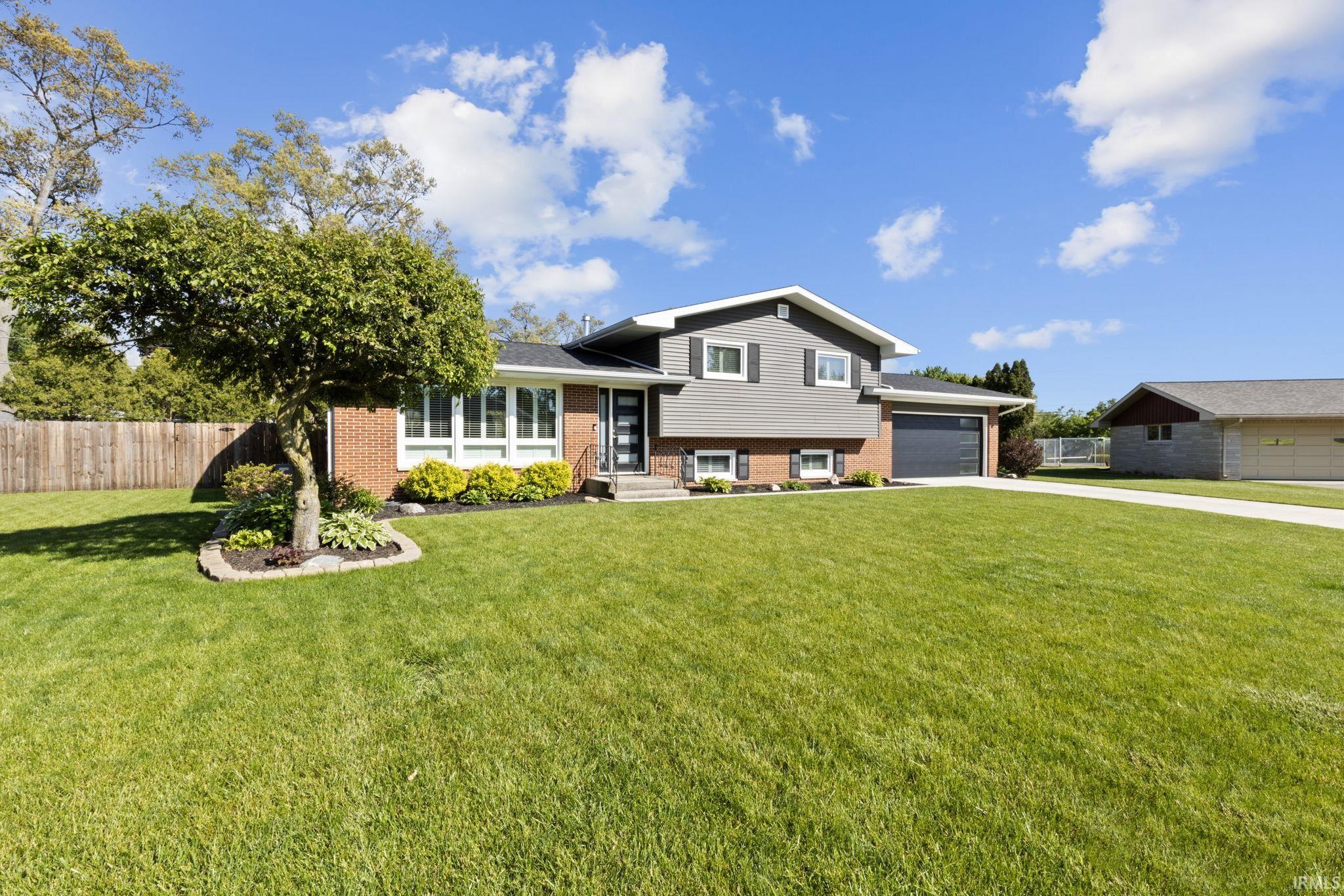 Split-level residence featuring a brick and siding exterior, an attached single-car garage, and a concrete driveway