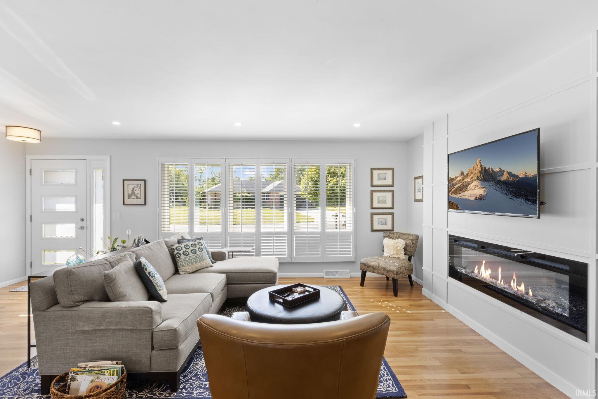 Living area featuring wood-finish flooring and recessed lighting