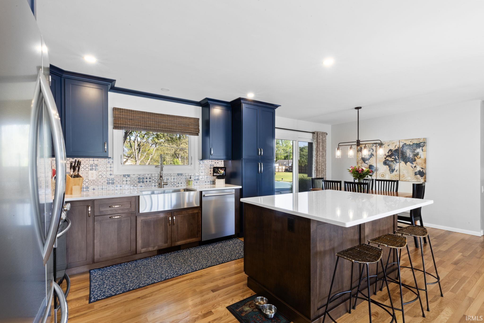 Open-concept kitchen featuring wood-finish flooring and a central island with a light-toned countertop