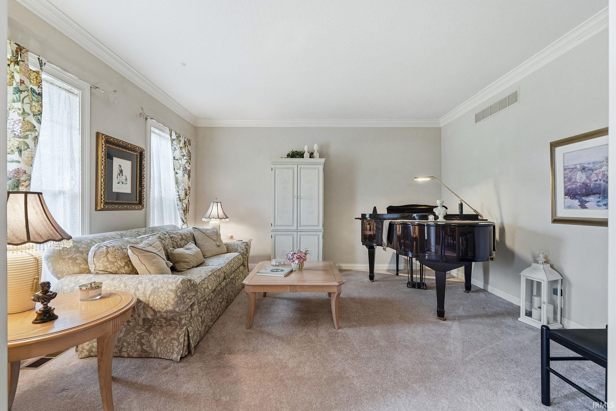 Light-toned carpeting complements neutral wall tones and white crown molding
