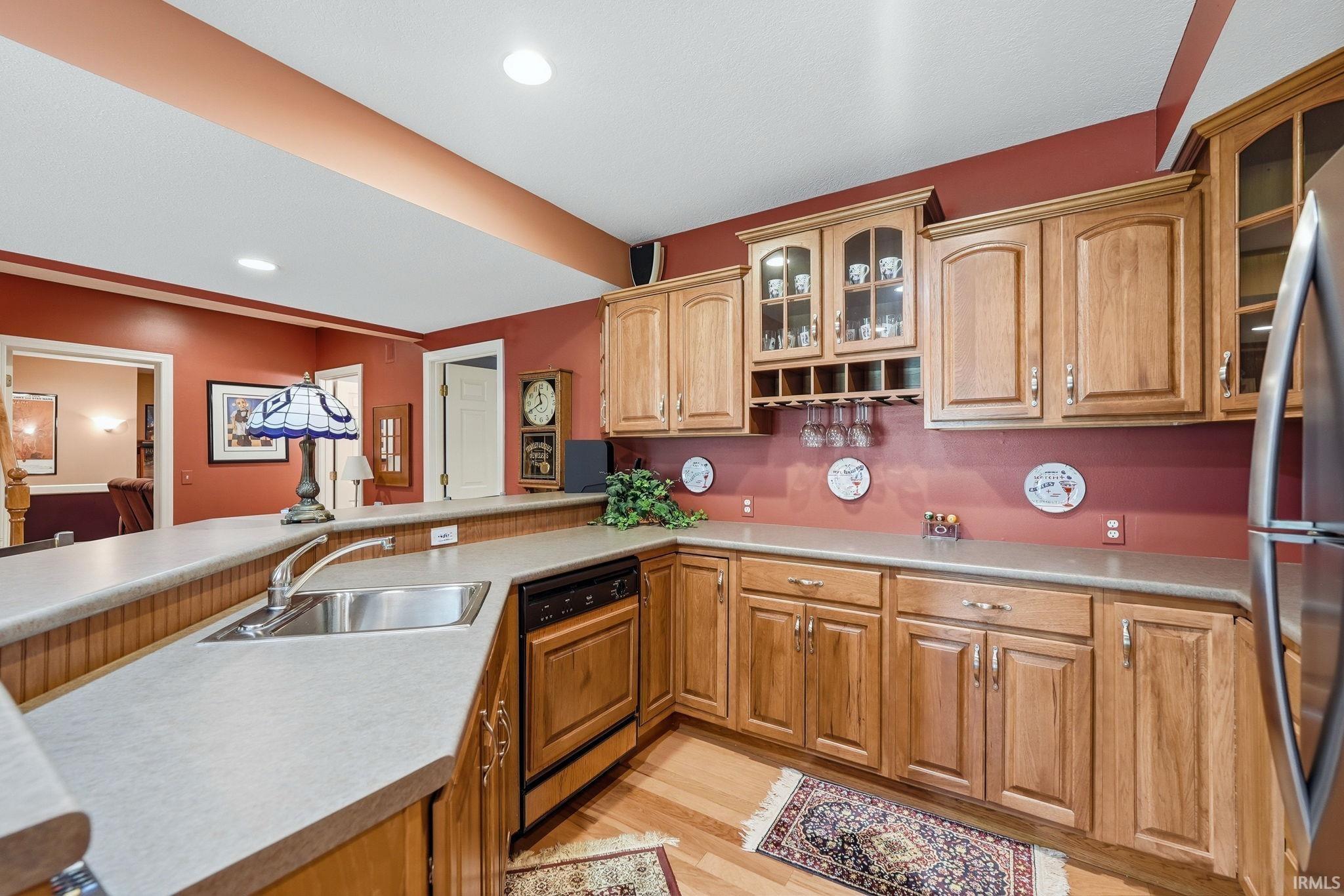 Kitchenette featuring wood-finish cabinetry, a built-in wine rack, and a stainless steel sink