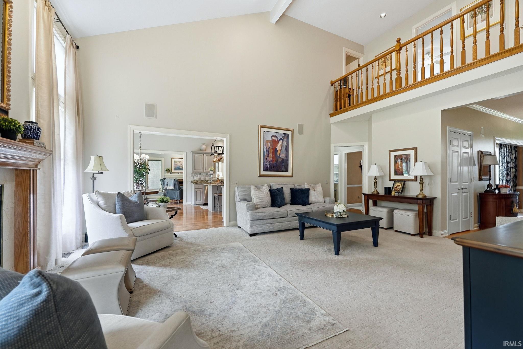 Two-story living area with vaulted ceilings and an upper-level wood spindle railing