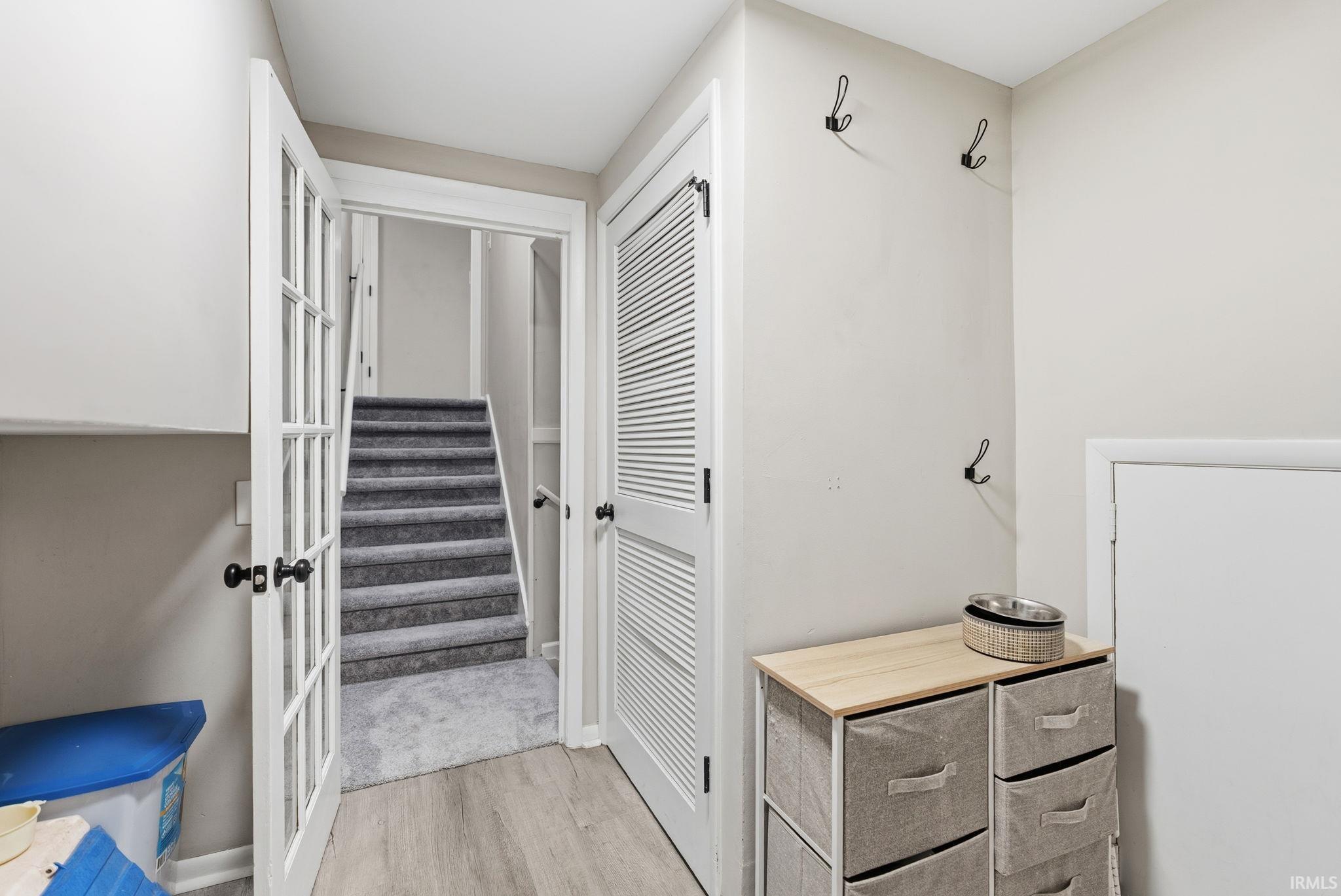 Light wood-finish flooring complements a gray carpeted staircase