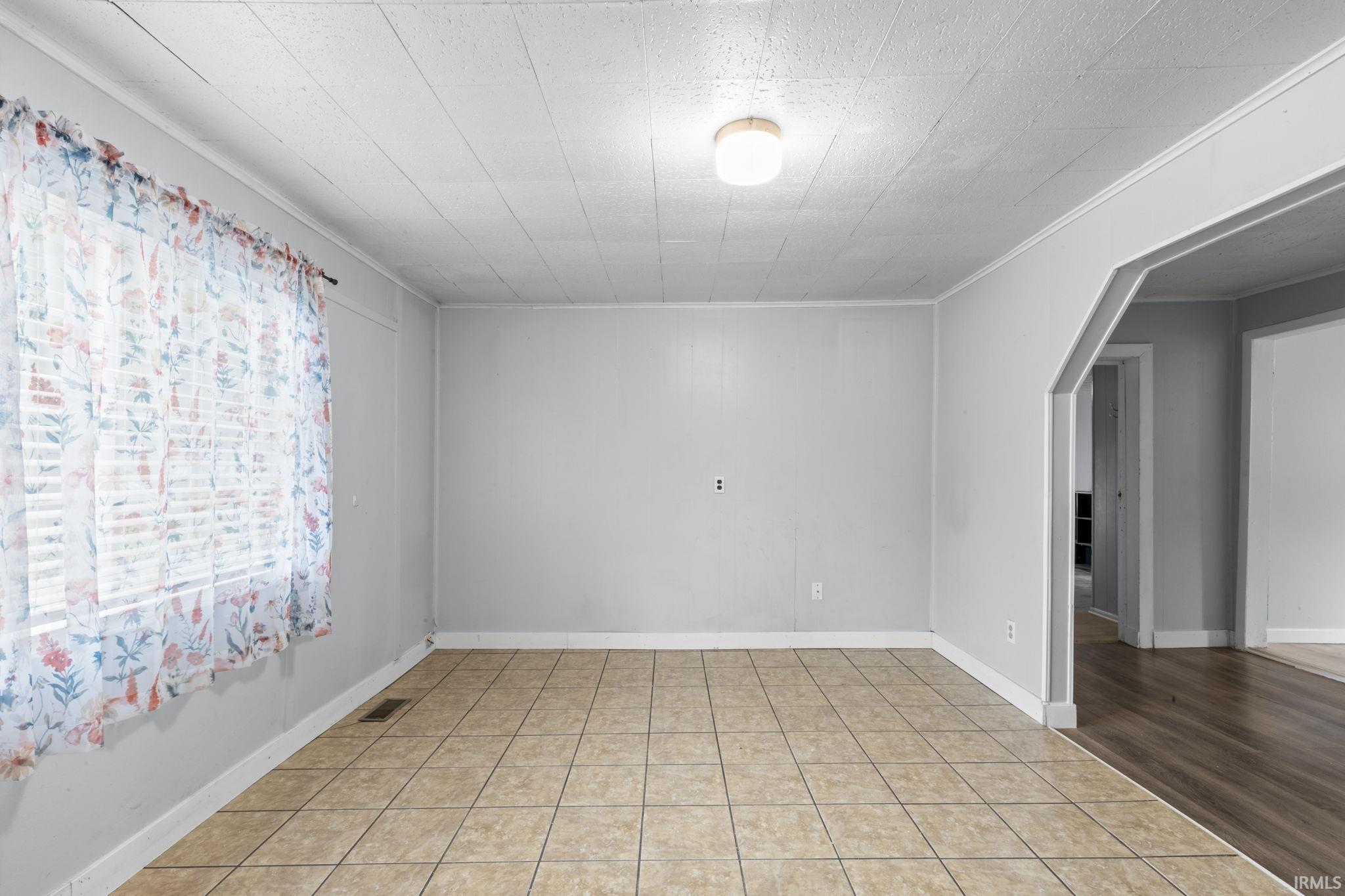 Spacious room with neutral wall tones and tile flooring