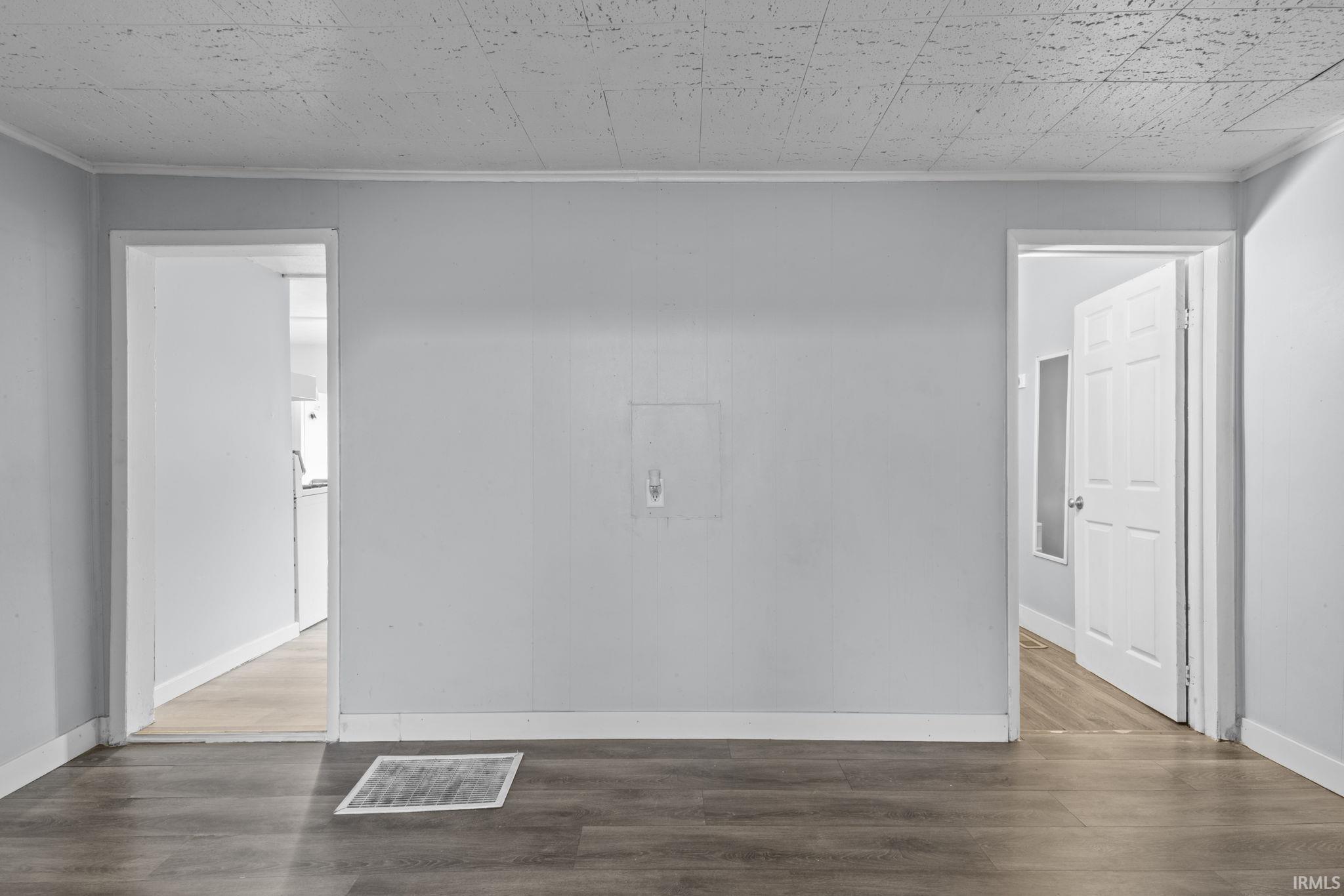 Interior space featuring wood-finish flooring, light gray wall paint, and white trim molding