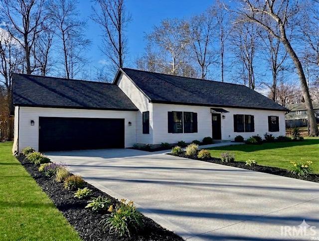Ranch-style residence featuring white horizontal siding and a dark shingle roof
