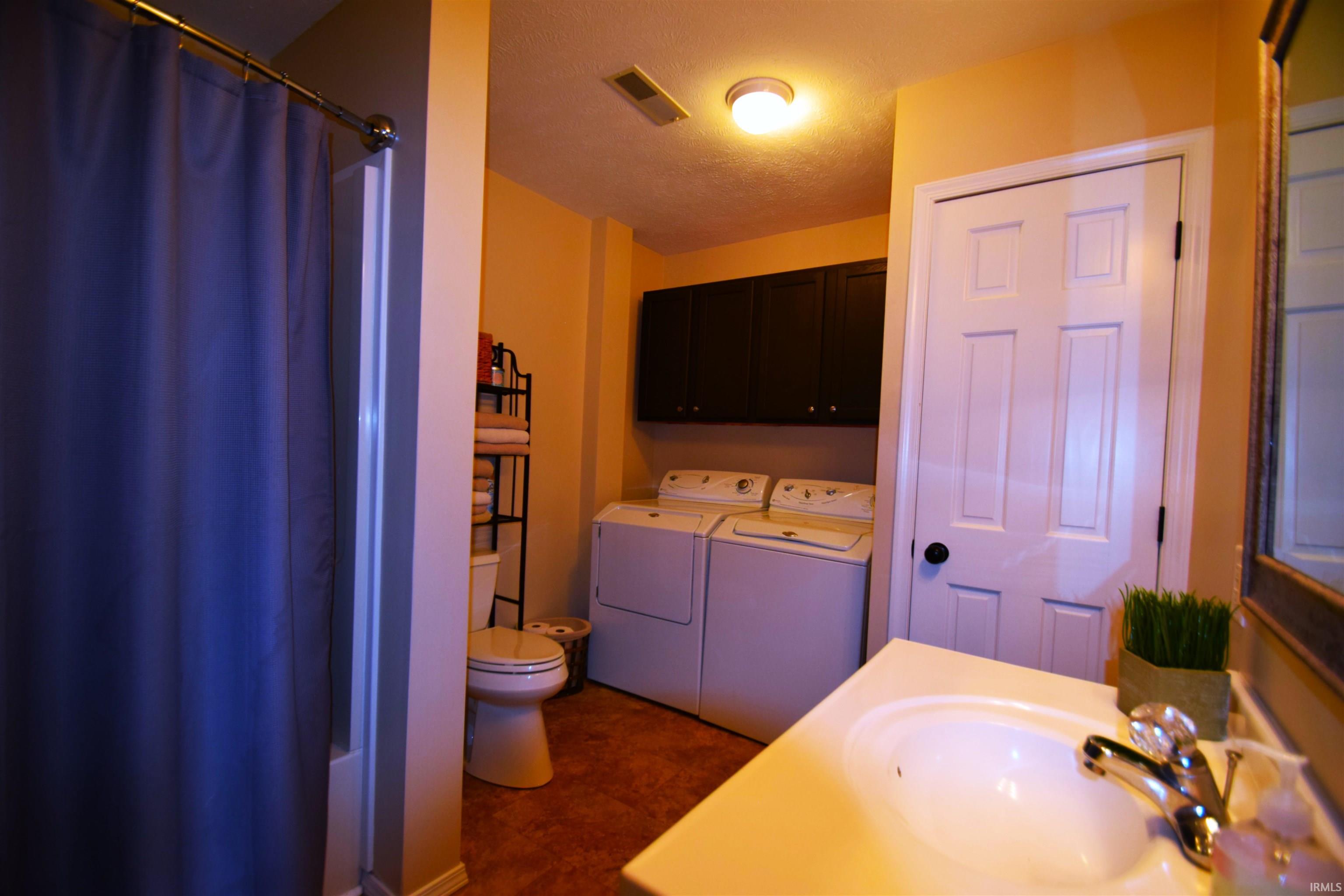 Bathroom featuring a white vanity with integrated sink, chrome faucet, and a shower/tub combination