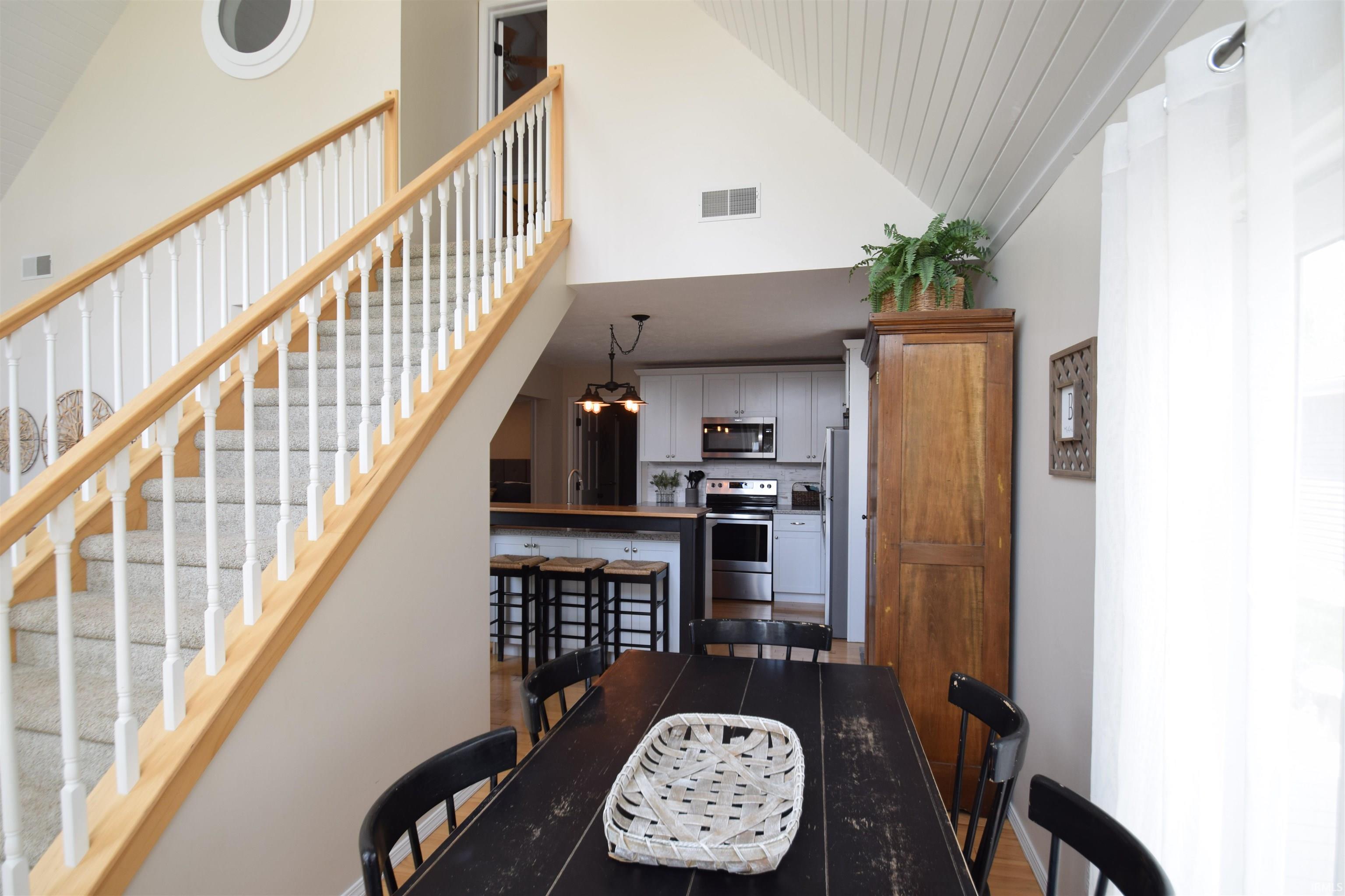 Vaulted ceiling with wood-finish paneling and an open-concept layout