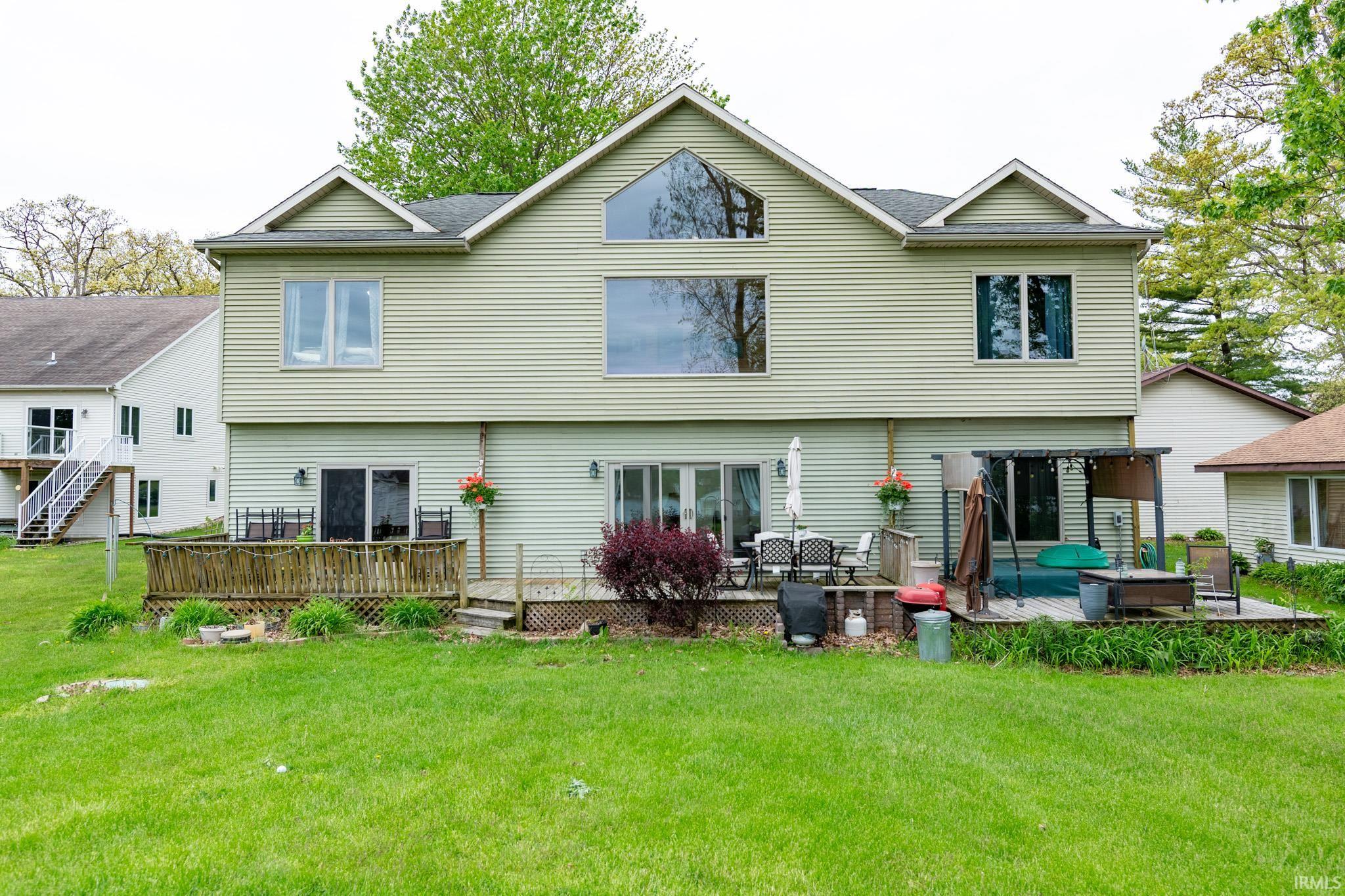 Rear exterior featuring horizontal siding, multiple windows, and two distinct deck areas