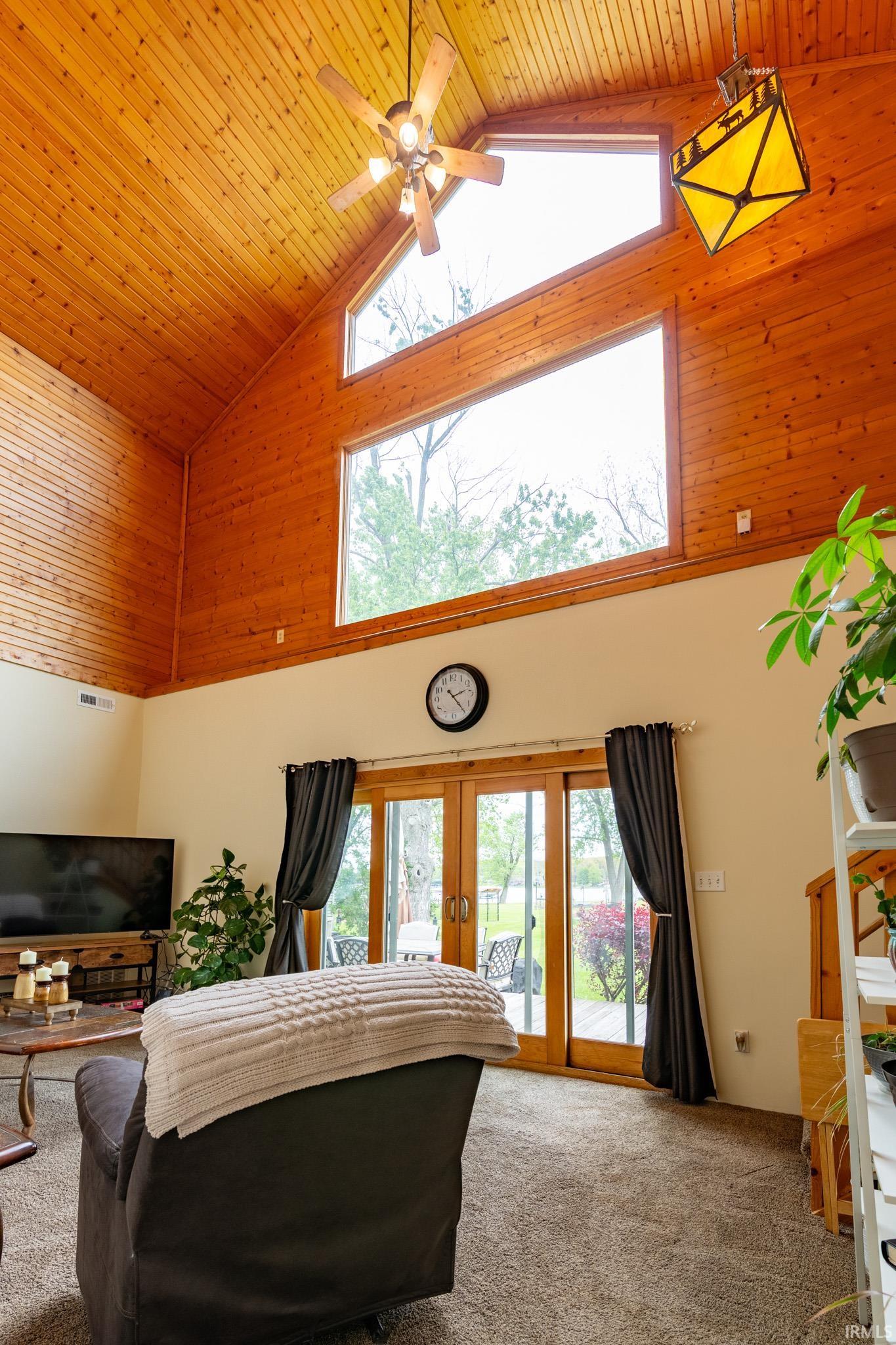 Vaulted wood-paneled ceiling with a central ceiling fan and an accent pendant light fixture