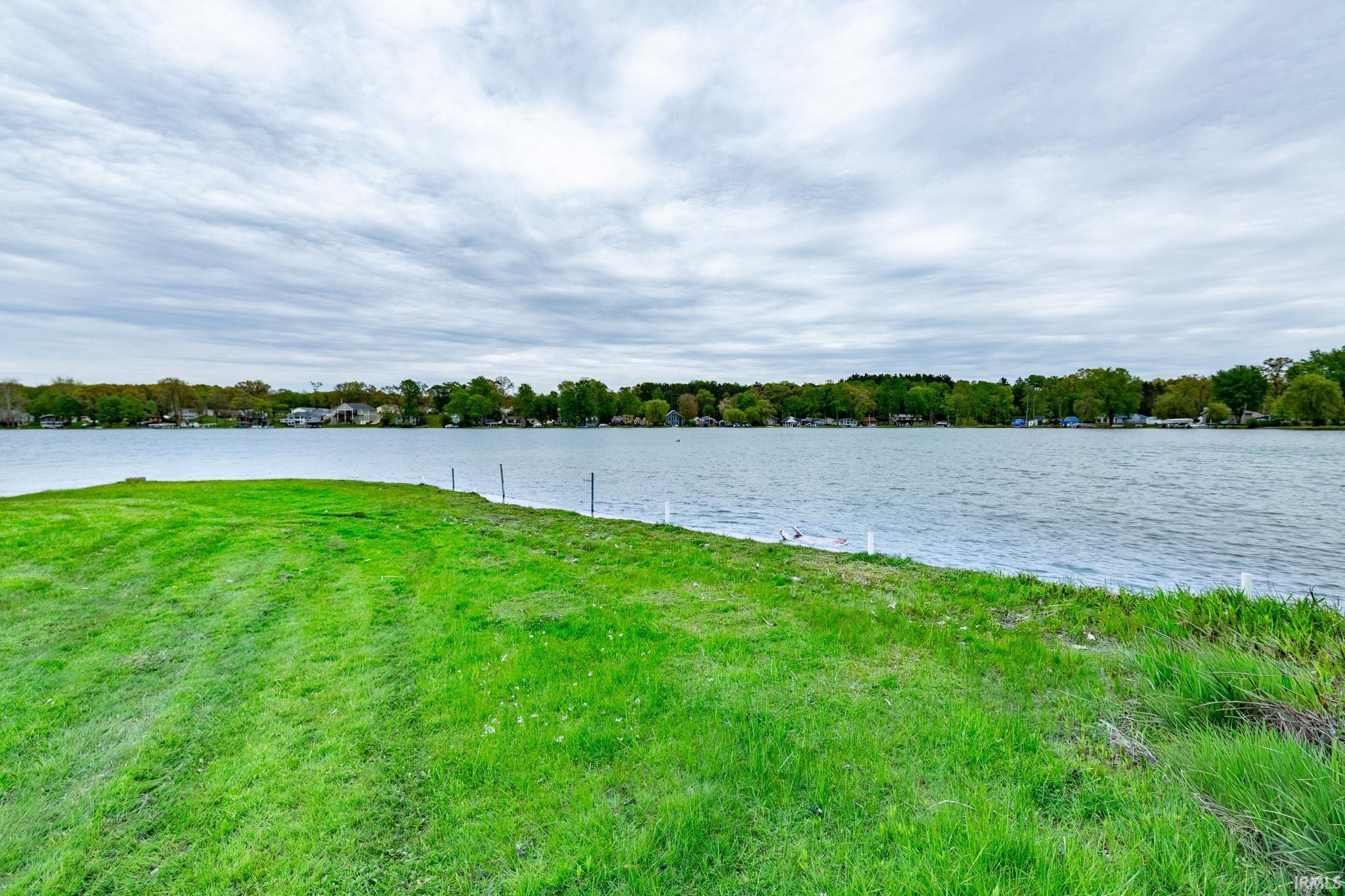Expansive waterfront property featuring a large grassy area and direct lake access