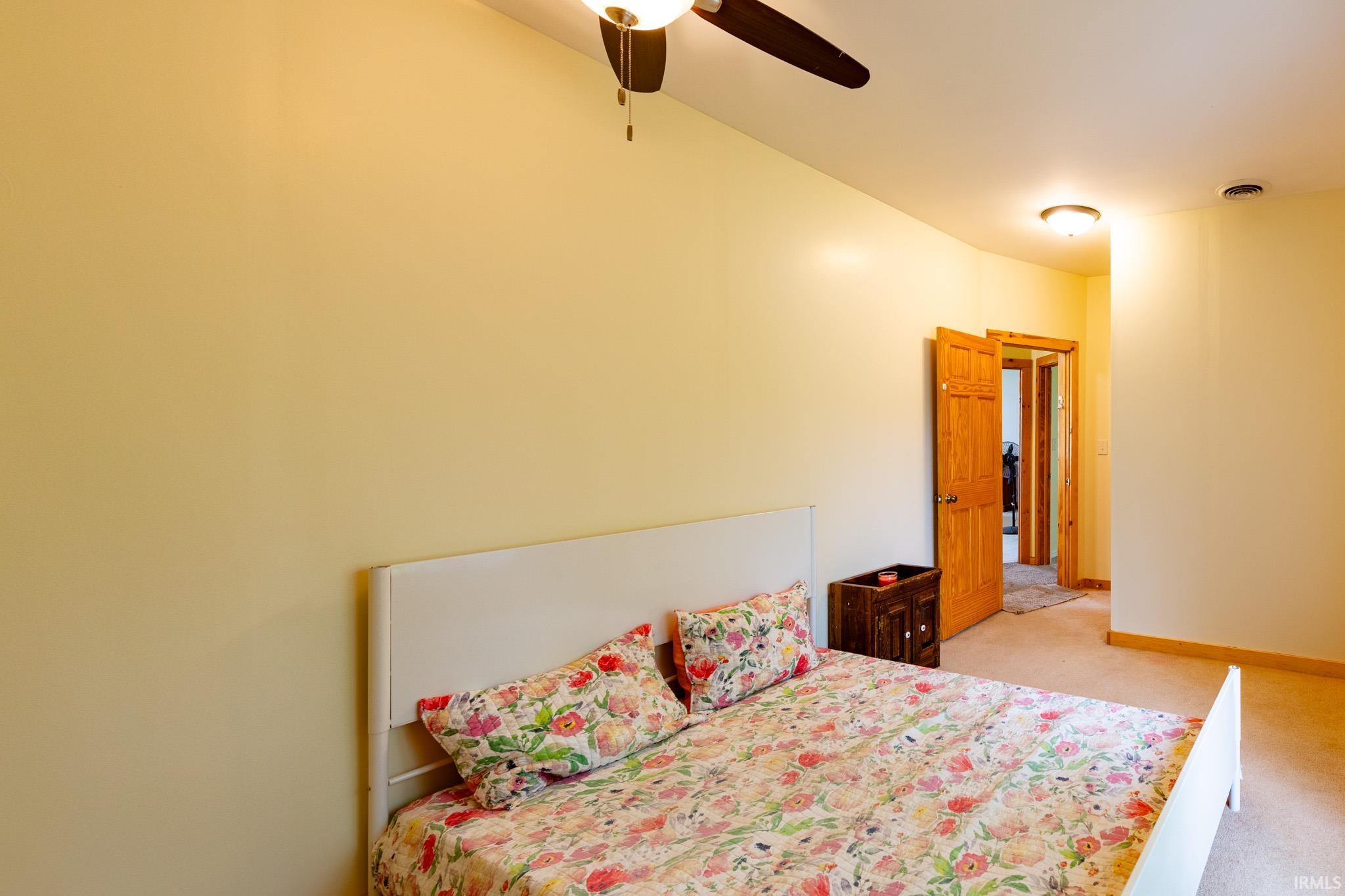 Carpeted room with a ceiling fan light fixture and recessed lighting