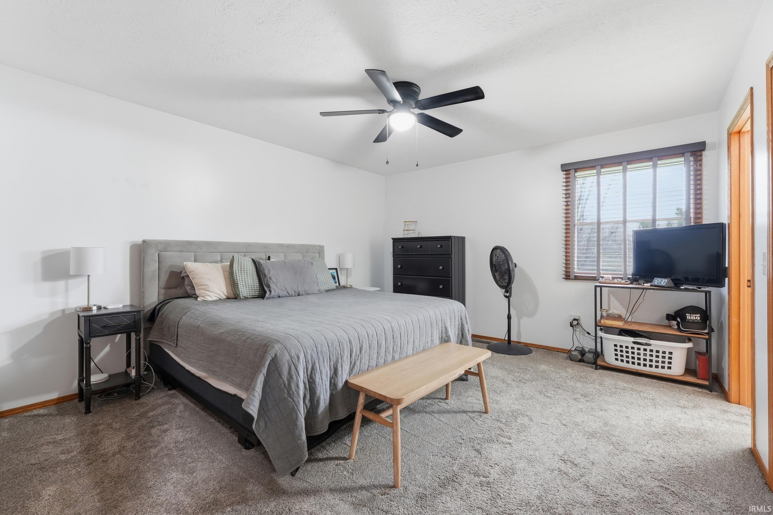 Carpeted bedroom with baseboards and ceiling fan