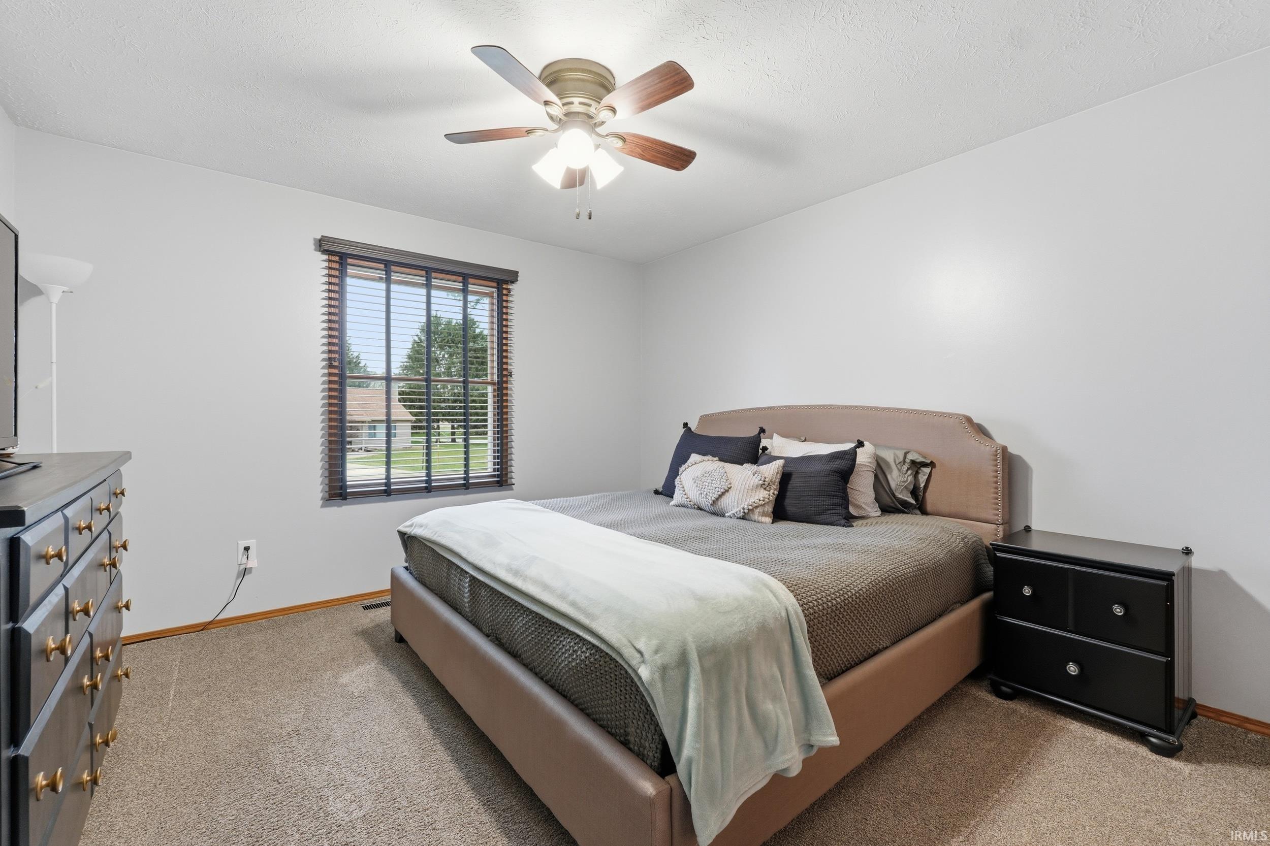 Bedroom with light carpet and ceiling fan