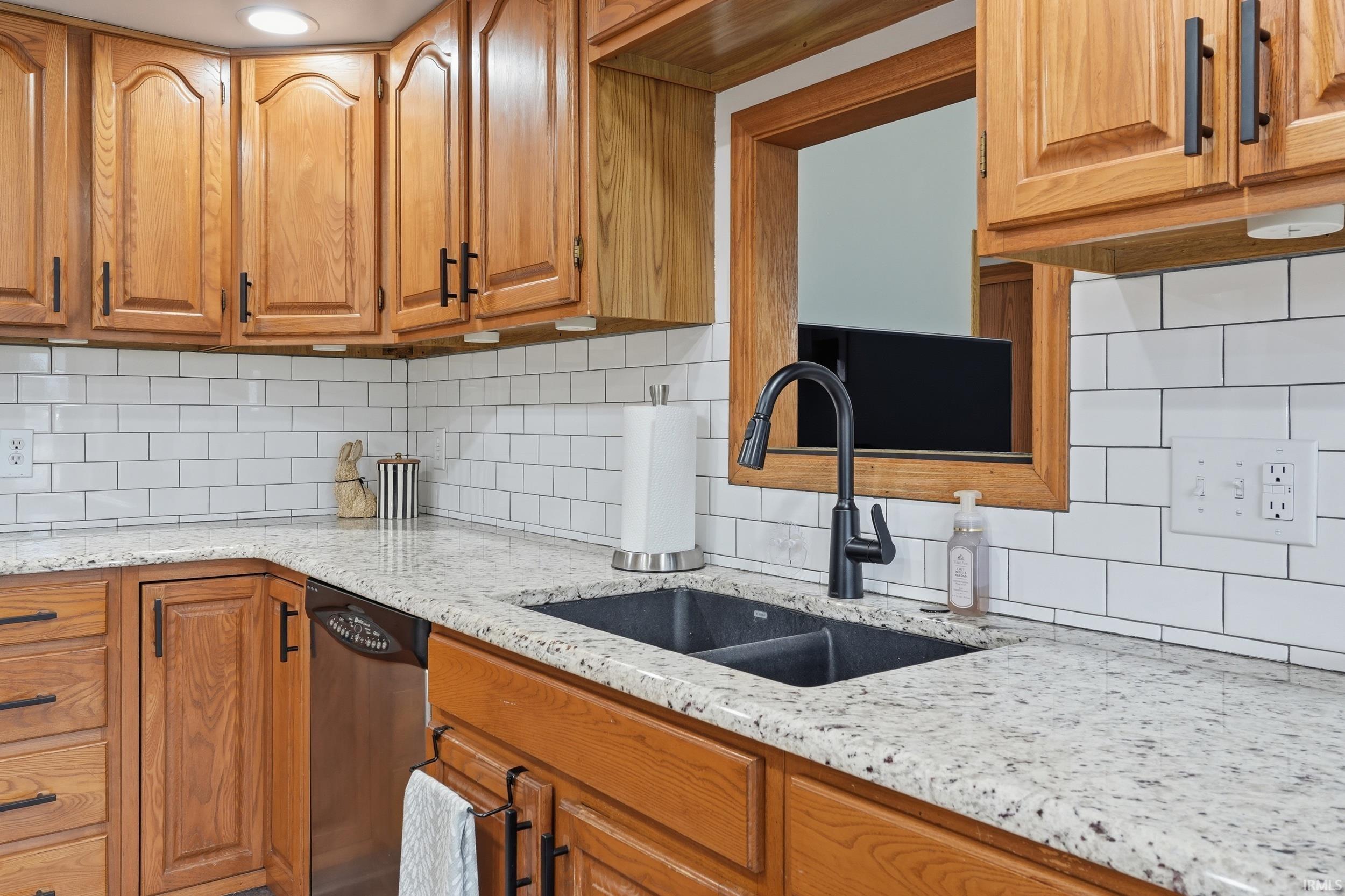Kitchen featuring light stone counters and wood finish cabinets