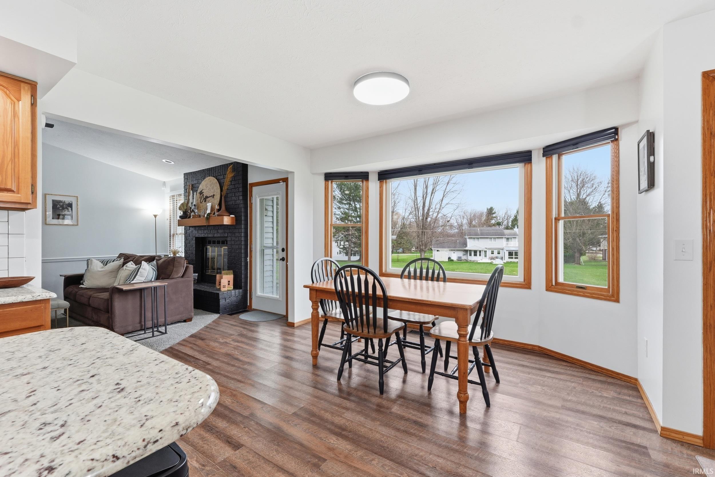 Dining room featuring a fireplace and dark wood-style floors