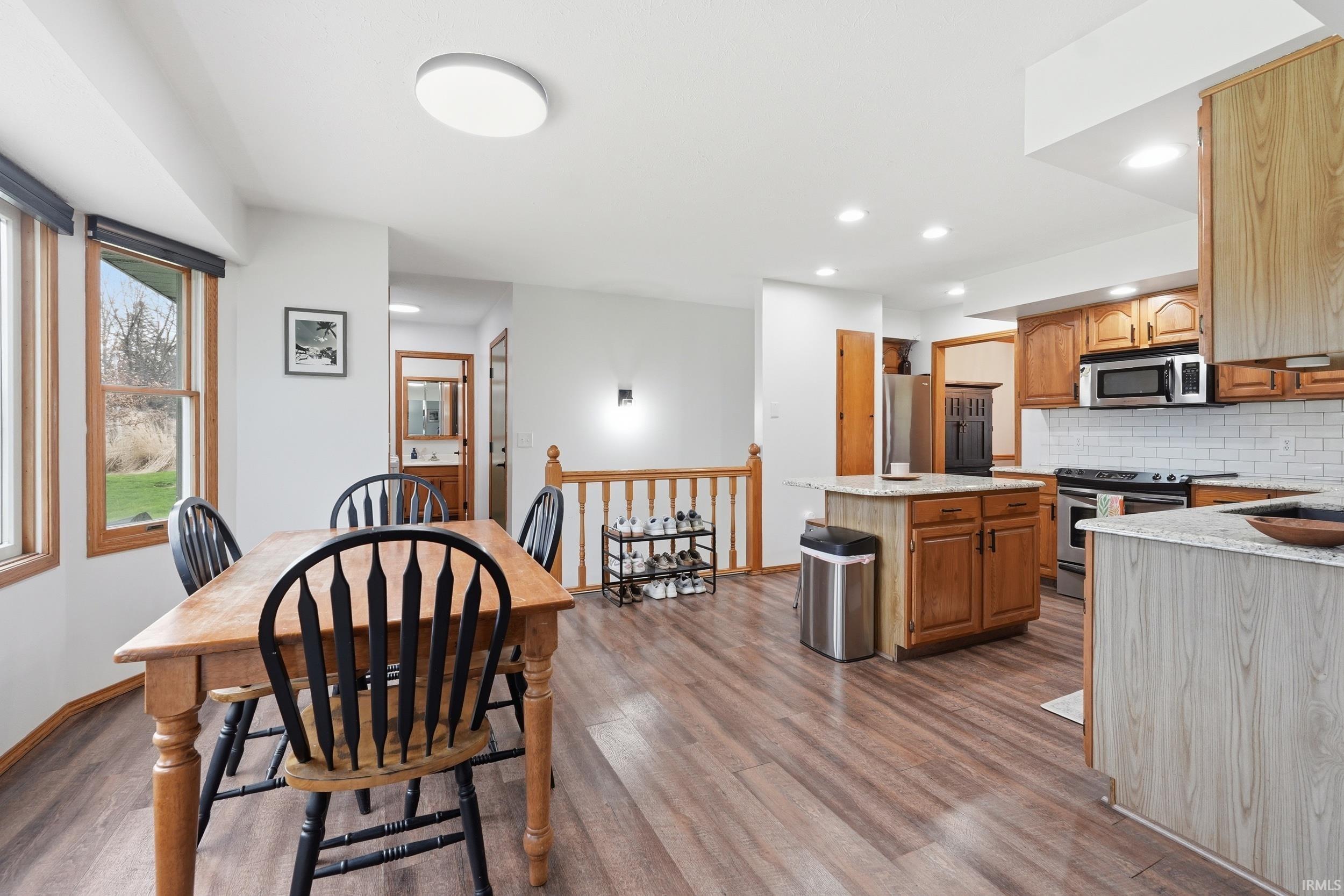 Dining space featuring dark wood-style flooring and recessed lighting